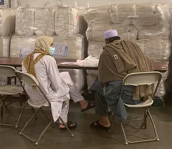 An Afghan family shares a meal at the Dulles Expo Center in Virginia, where thousands of Afghan refugees arrive daily for processing and rest before they are sent to U.S. bases around the country.