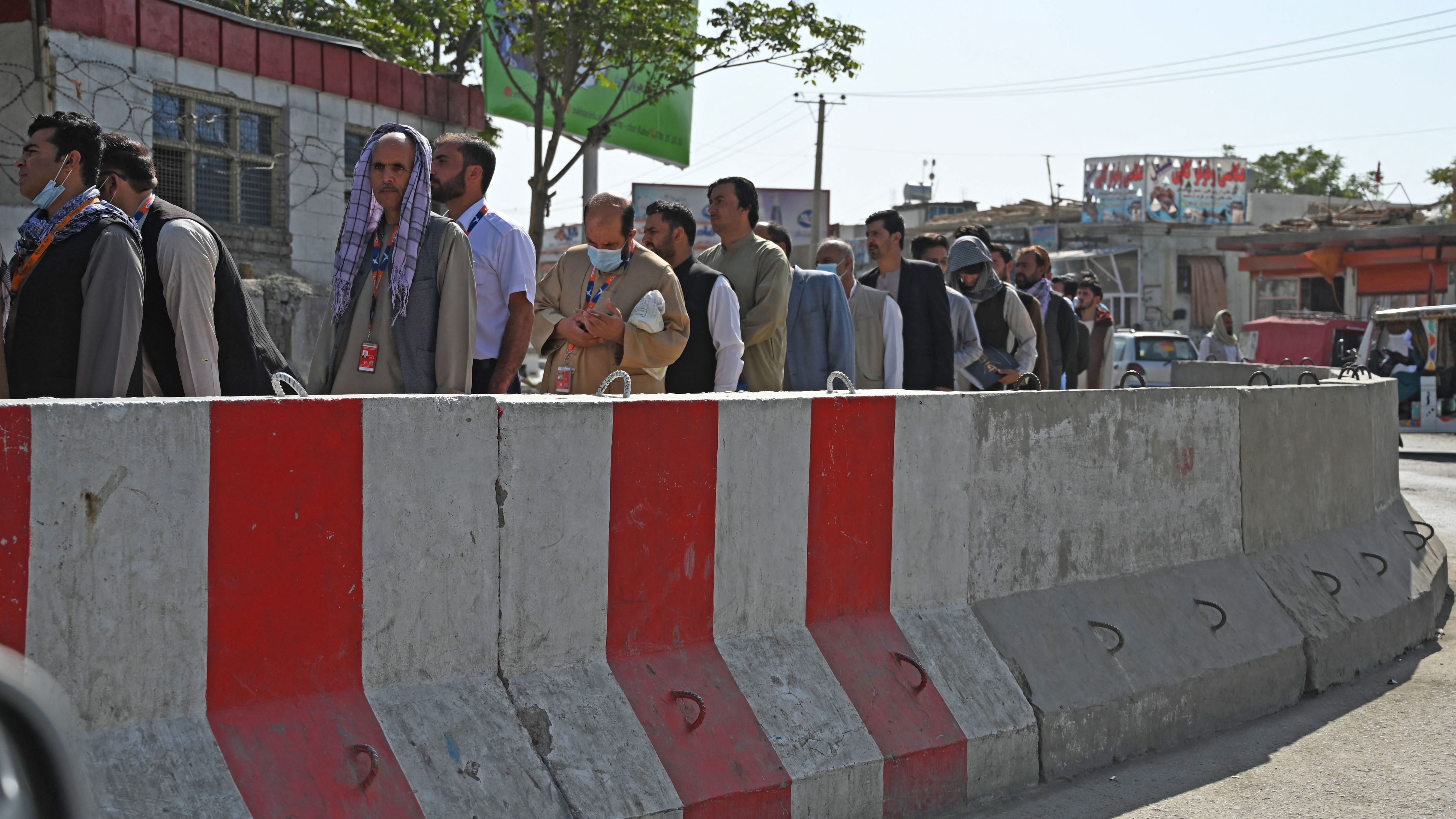 Airport workers stand in a queue at a check point before entering the Kabul International Airport in Kabul on Sept. 4.