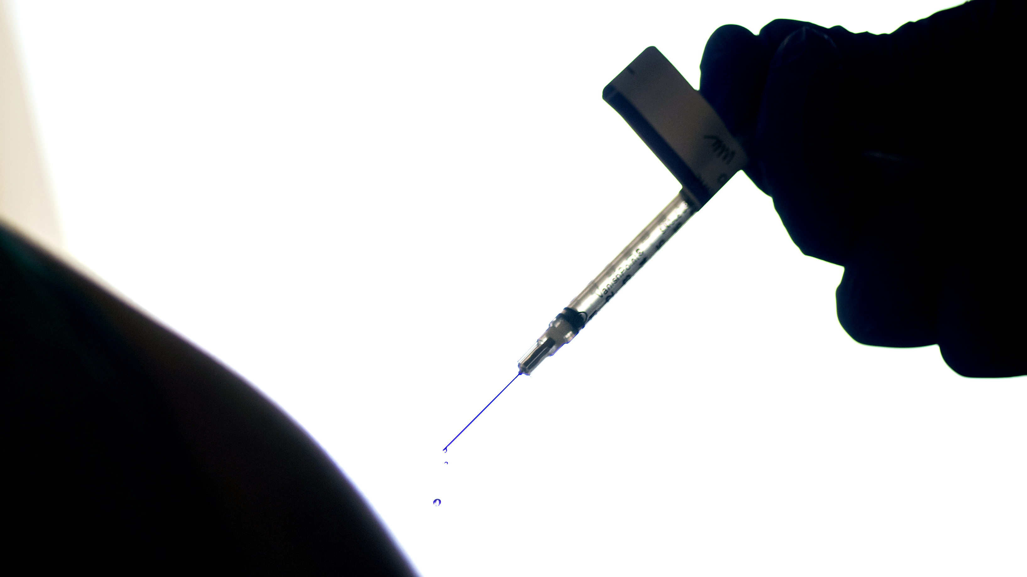 A droplet falls from a syringe after a health care worker was injected with the Pfizer COVID-19 vaccine last year at a hospital in Providence, R.I.