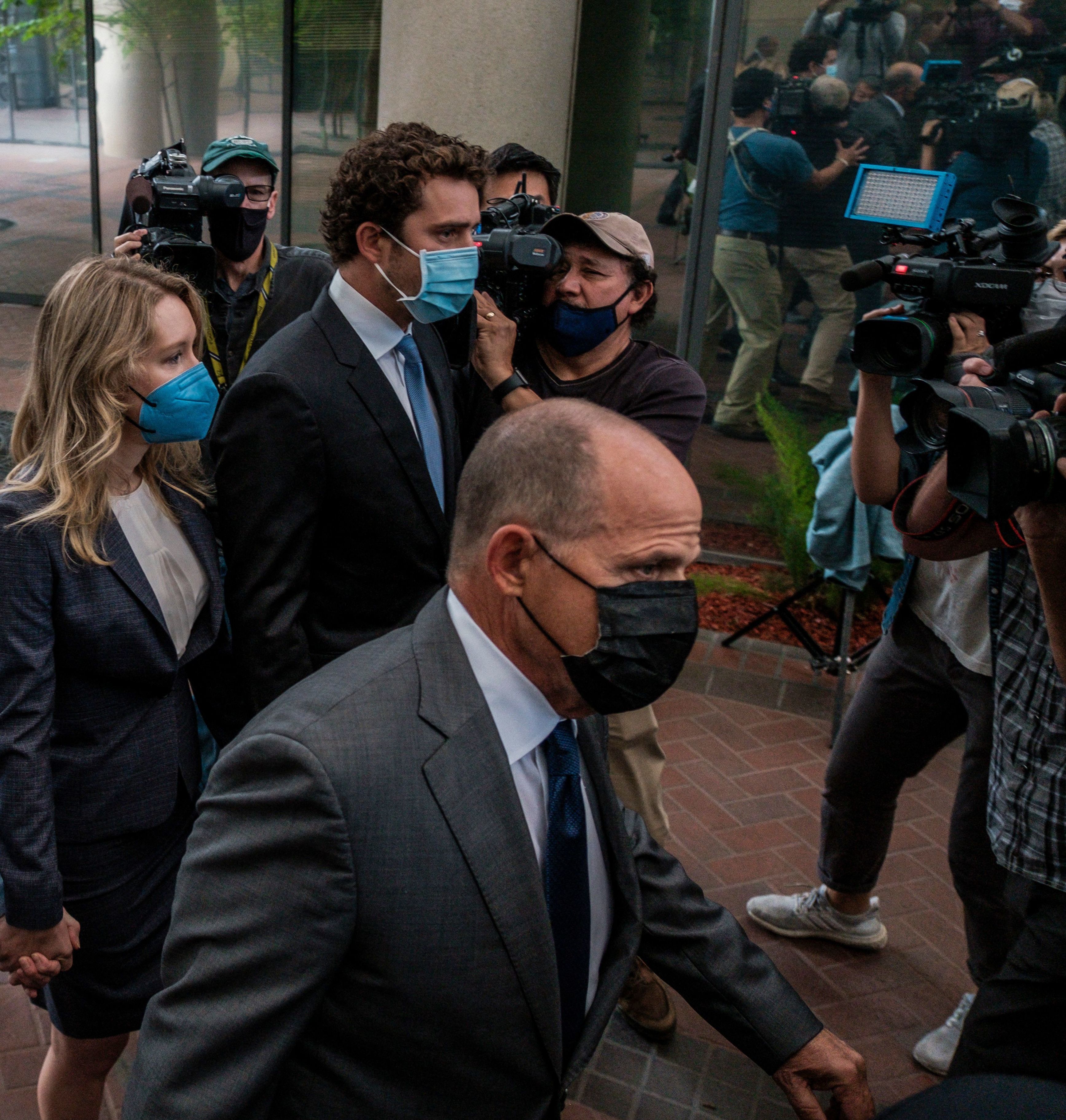 Bill Evans (center), the father of Billy Evans, Elizabeth Holmes' partner, accompanies Holmes into a federal courthouse in San Jose, Calif., for the start of her federal fraud trial. (AFP via Getty Images)