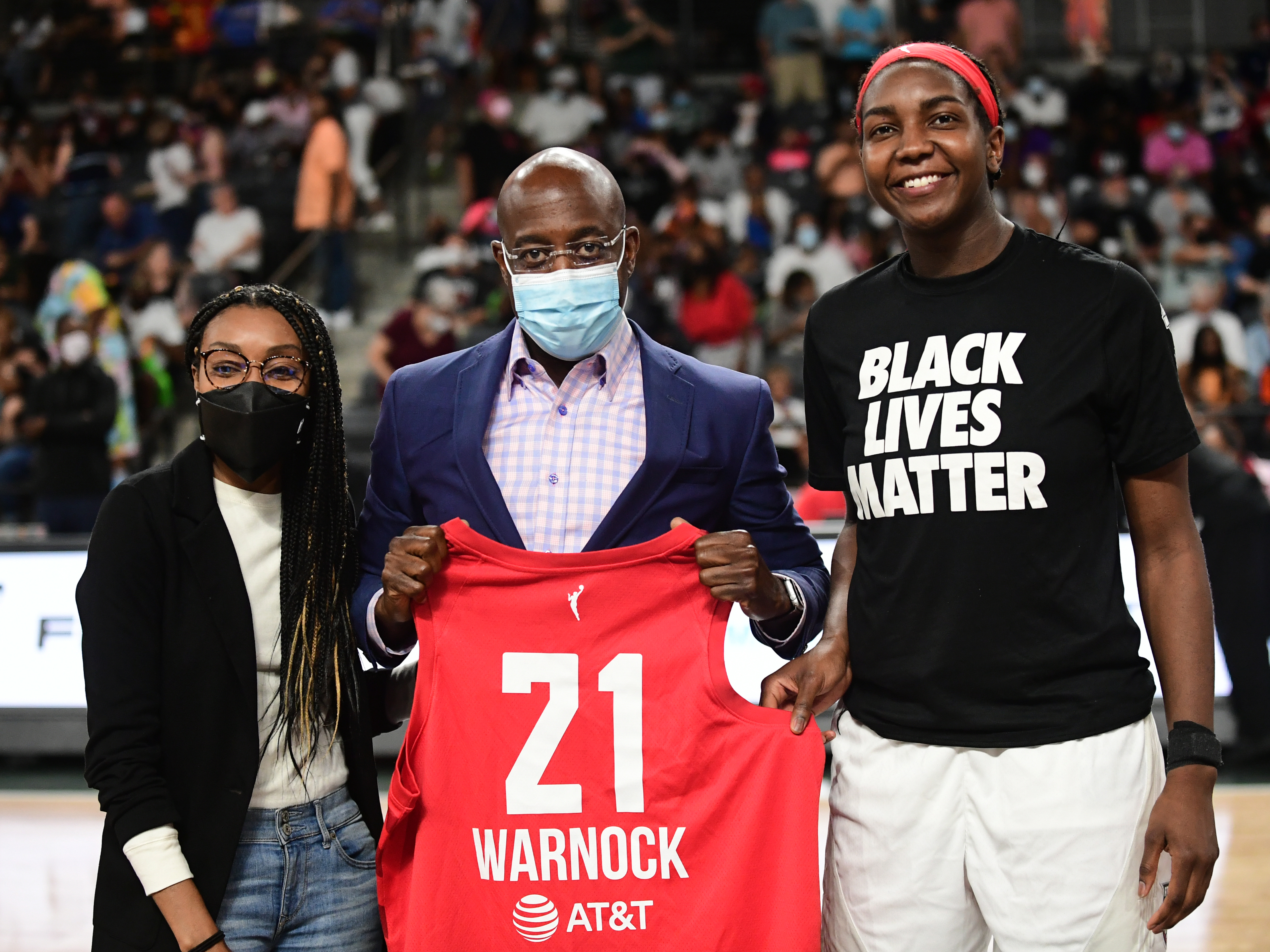 Vice President Renee Montgomery and Elizabeth Williams #1 of the Atlanta Dream present Reverend Raphael Warnock with a Atlanta Dream jersey during the game against the Phoenix Mercury on August 21, 2021 at Gateway Center Arena in College Park, Georgia. (NBAE via Getty Images)