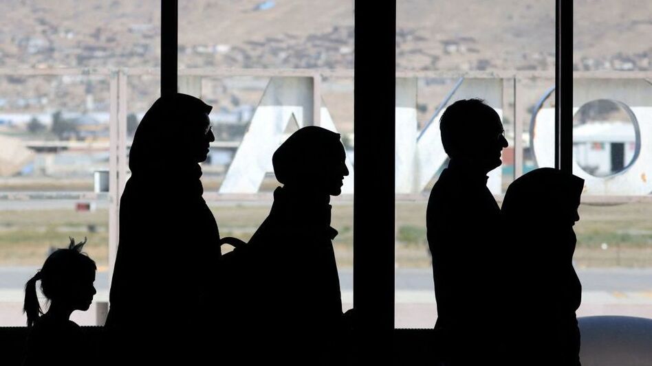 People leave to board a flight at the airport in Kabul on Monday. Leaving Afghanistan for the U.S. has become a huge challenge now that American troops and embassy staff have left the country. (Karim Sahim/AFP via Getty Images)