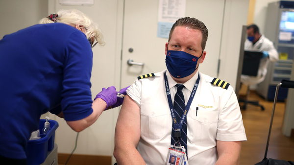 United Airlines pilot Steve Lindland receives a COVID-19 vaccine at O'Hare International Airport.