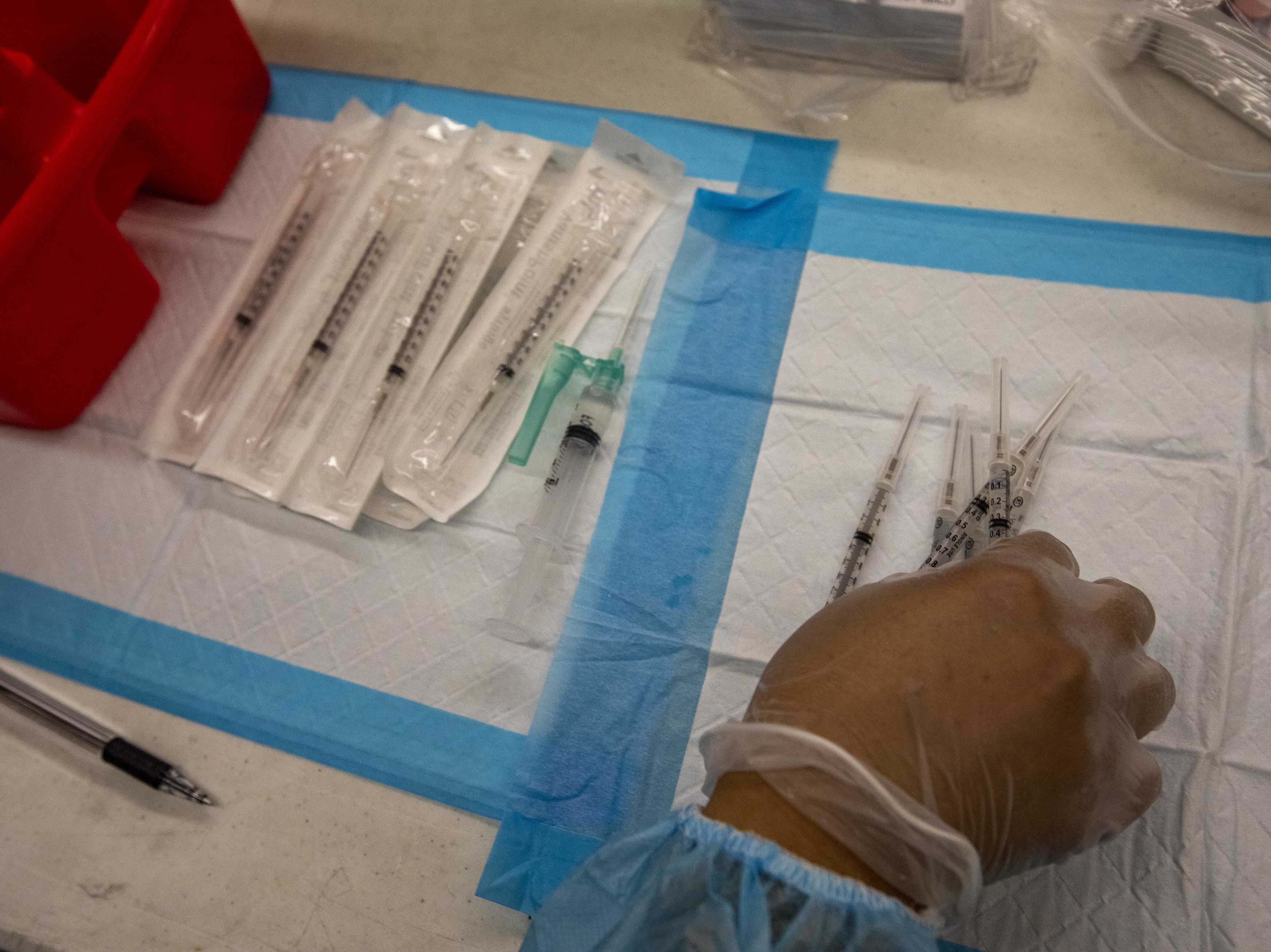 A healthcare worker prepares doses of the Pfizer-BioNTech Covid-19 vaccine at a mobile vaccination clinic at a high school in Los Angeles in August. (Bloomberg via Getty Images)
