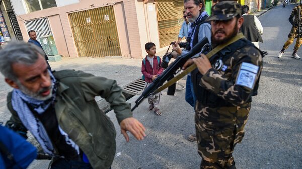 A member of the Taliban special forces pushes a journalist covering a demonstration by women protesters in Kabul on Sept. 30.