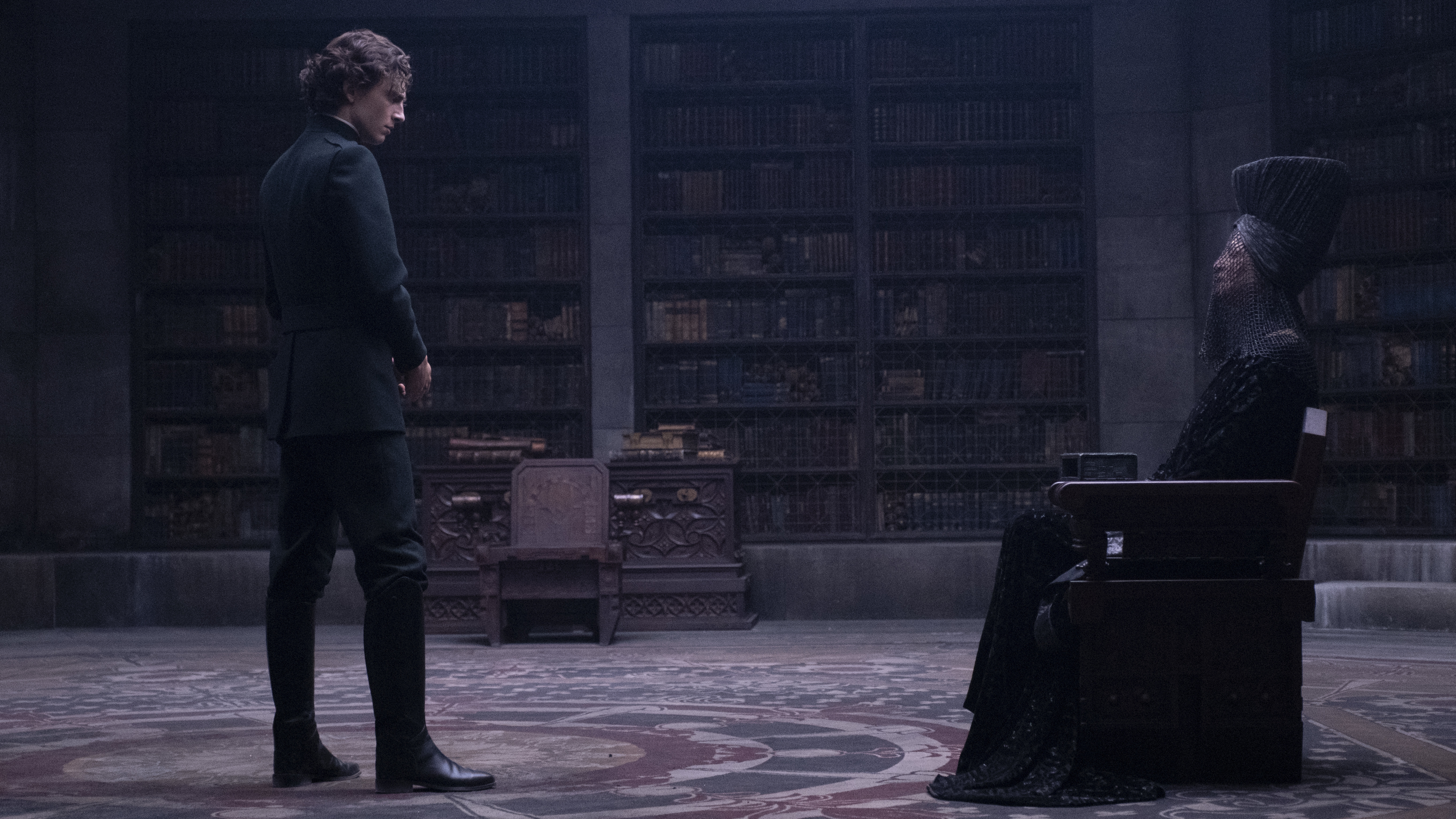 Paul (Timothee Chalamet) and the Bene Gesserit Reverend Mother (Charlotte Rampling) regard each other warily in DUNE. (Warner Bros.)