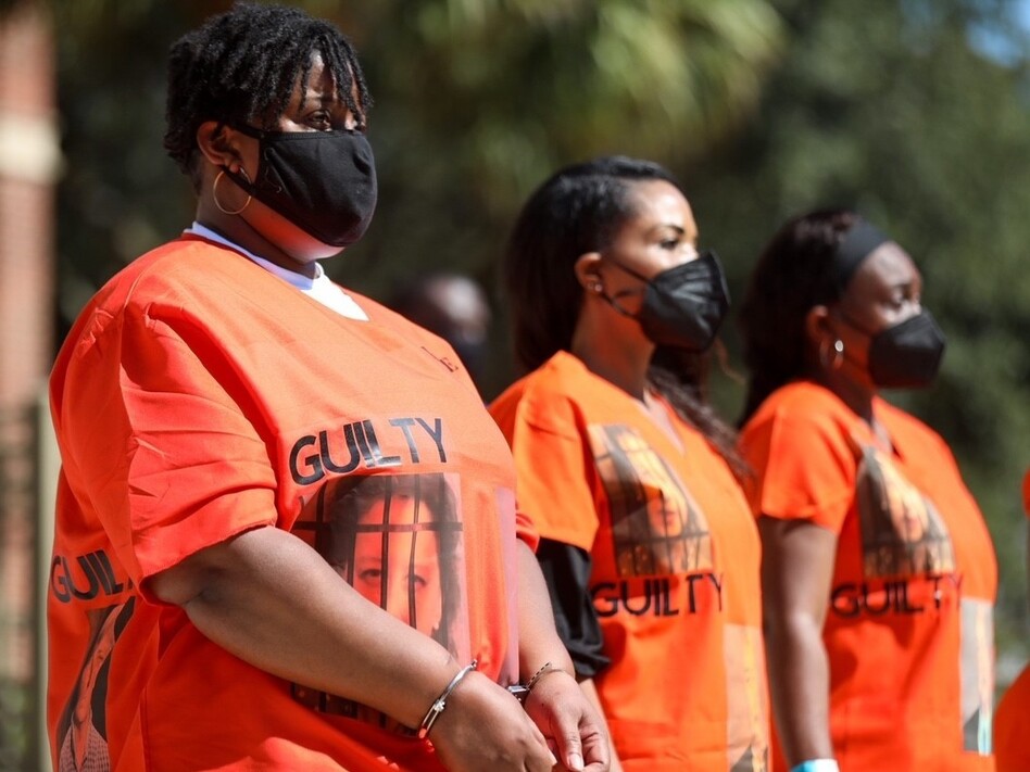 Outside of the Glynn County Courthouse, Ahmaud Arbery's aunt, Thea Brooks, joins a group during a demonstration calling for the conviction of the three men who face charges in the death of Ahmaud Arbery and other county officials they say were complicit in his death. (Riley Bunch/Georgia Public Broadcasting )