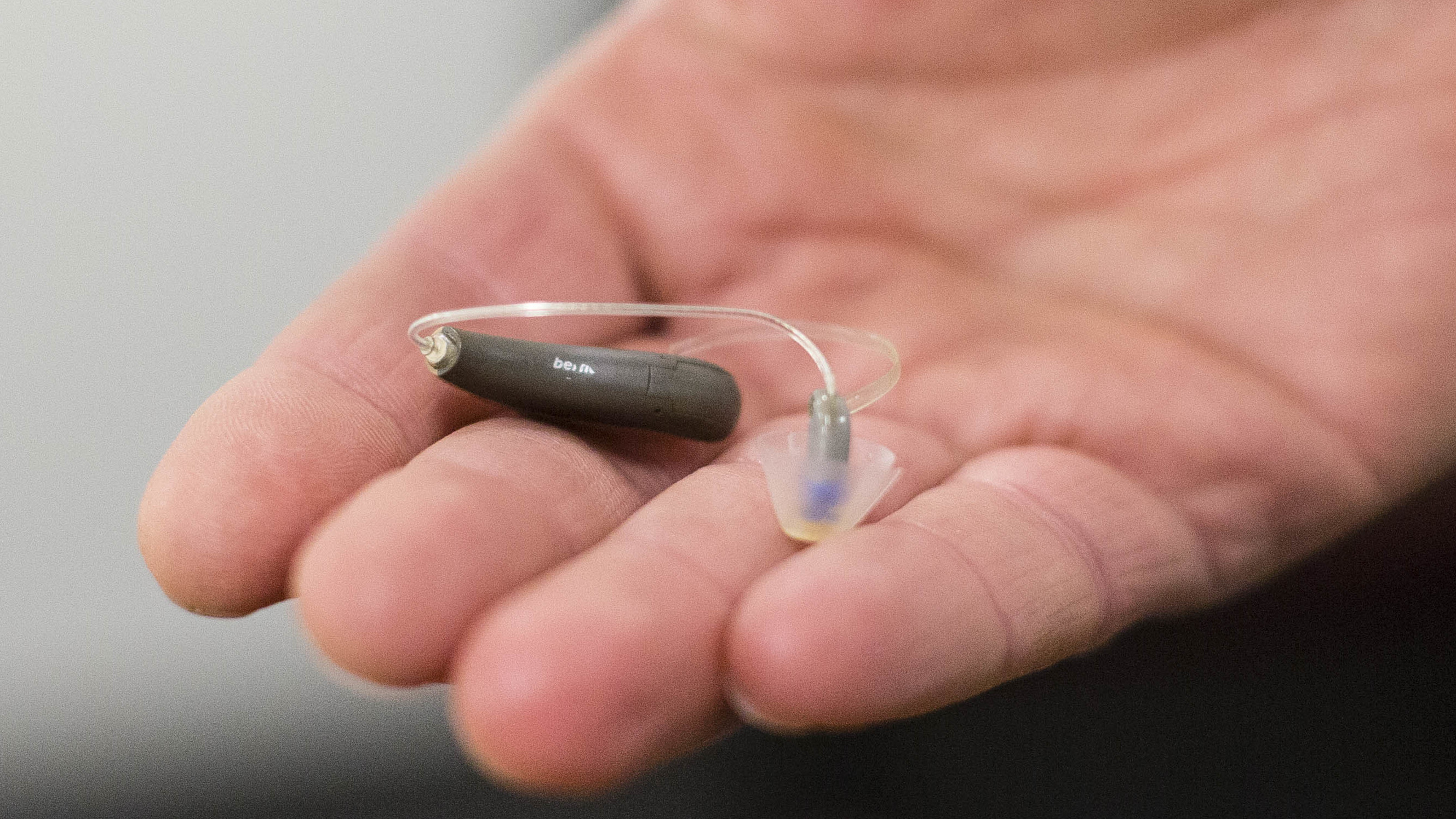 The Food and Drug Administration is moving to approve over-the-counter hearing aids in a change that lawmakers and advocates have long called for. Here, a man displays his hearing aid before taking part in a meeting. (Boston Globe via Getty Images)