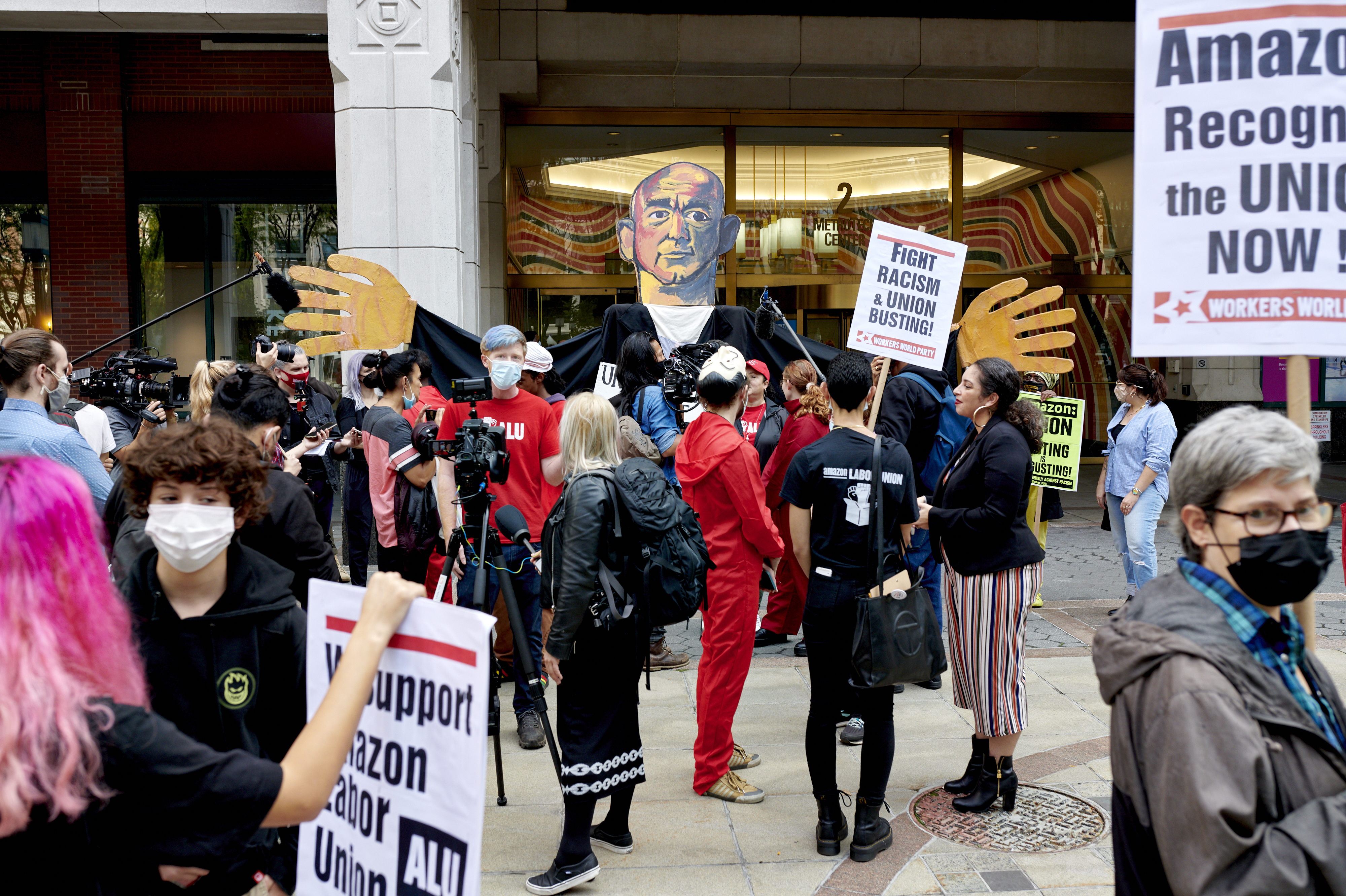 Workers and supporters hold signs after filing a petition requesting an election to form a union outside the National Labor Relations Board (NLRB) regional office in the Brooklyn Borough of New York, U.S., on Monday, Oct. 25, 2021. Amazon.com Inc. workers hoping to unionize four company facilities in Staten Island formally filed a petition with federal labor officials to hold a union election. (Bloomberg via Getty Images)