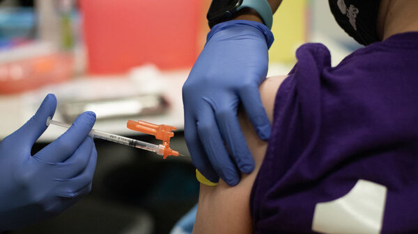 A health care worker administers a dose of the Pfizer-BioNTech COVID-19 vaccine to a child at a pediatrician's office in Bingham Farms, Michigan.