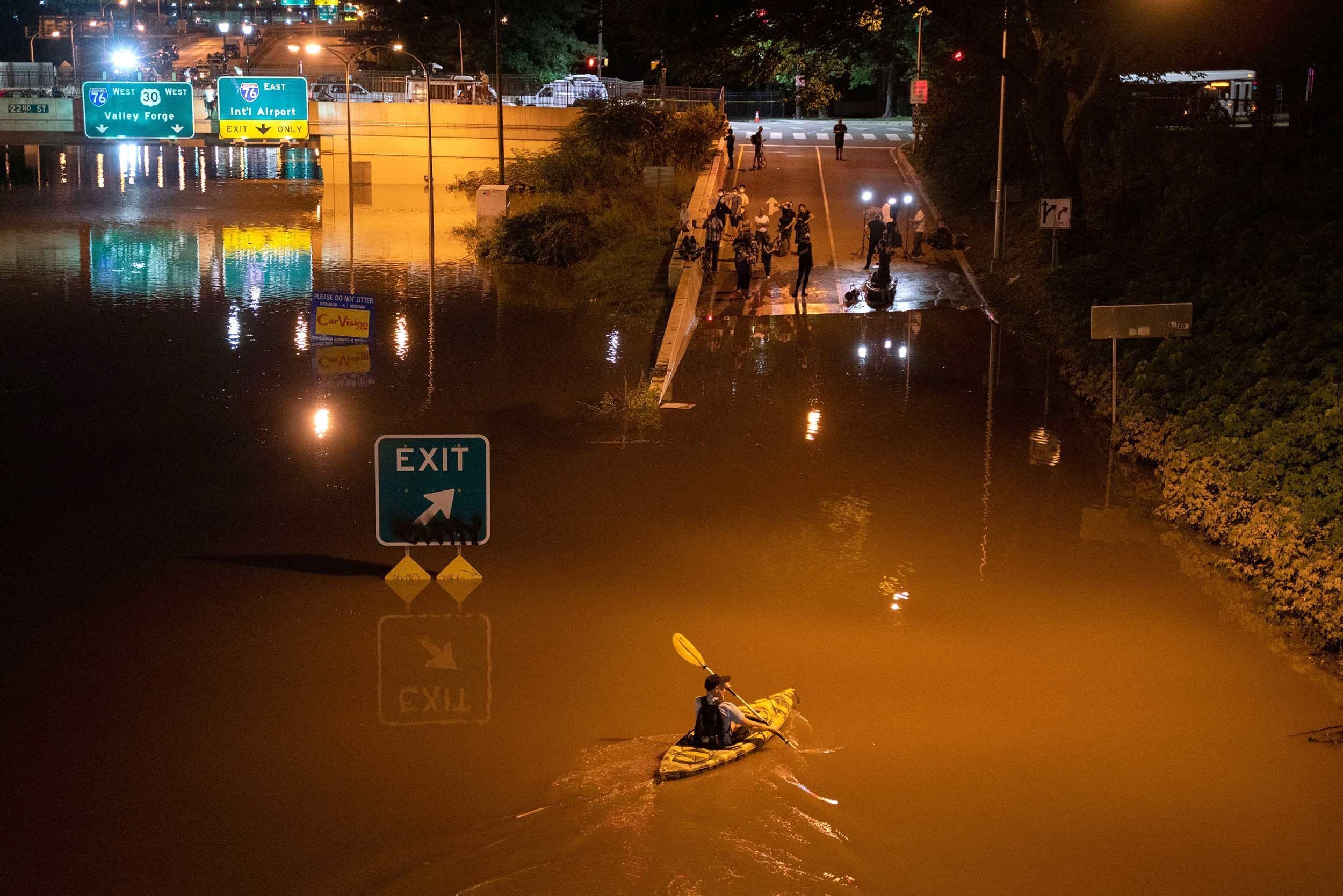 A kayaker paddles down an interstate in Pennsylvania after flooding from Hurricane Ida earlier this year. Several dozen people died, some in cars and basement apartments, during extreme flash flooding. (AFP via Getty Images)