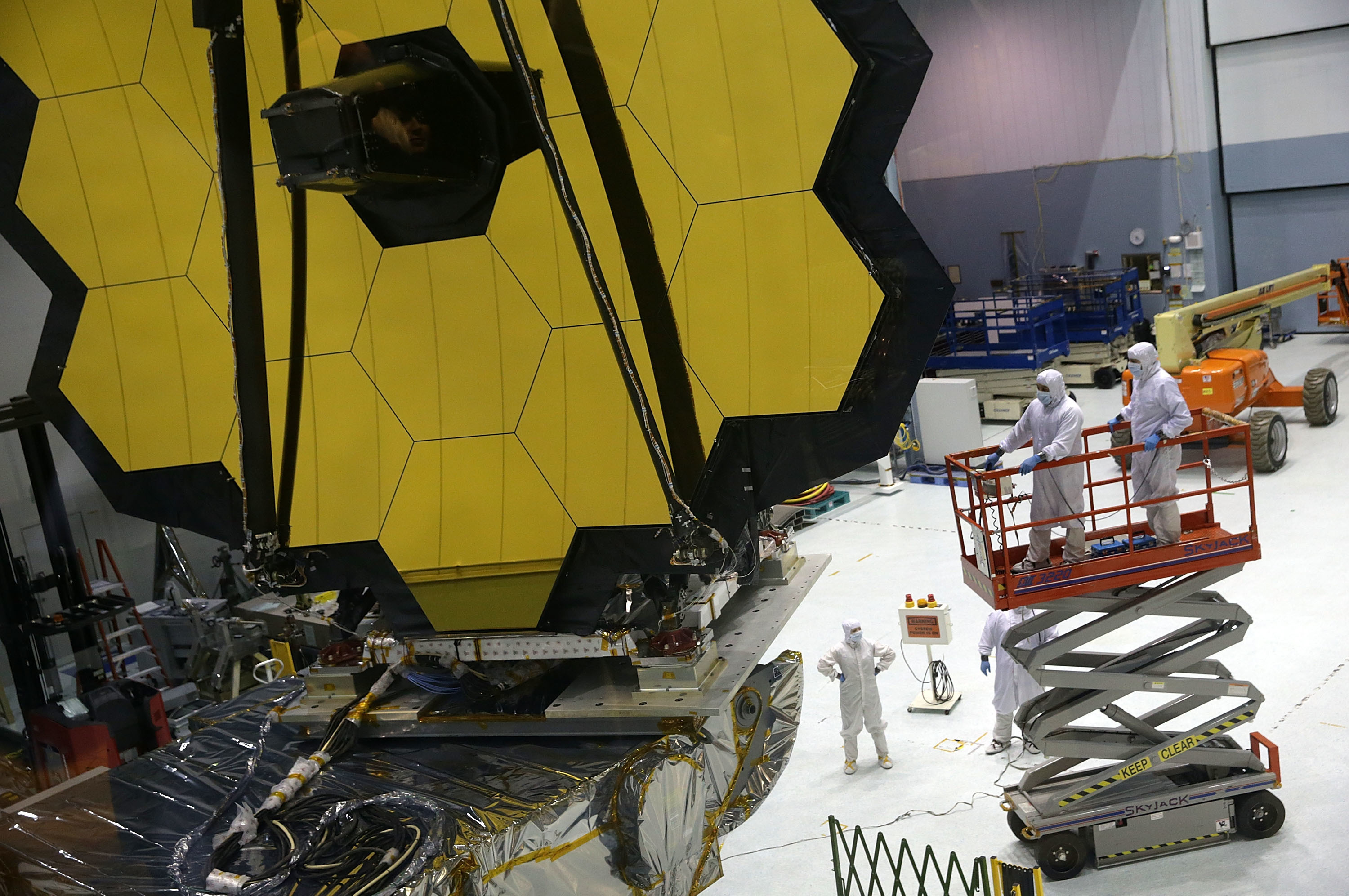 Technicians work on NASA's James Webb Space Telescope, which will launch in December. Astronomers say the next big telescope should be designed to search signs of life on planets that orbit distant stars. (Getty Images)
