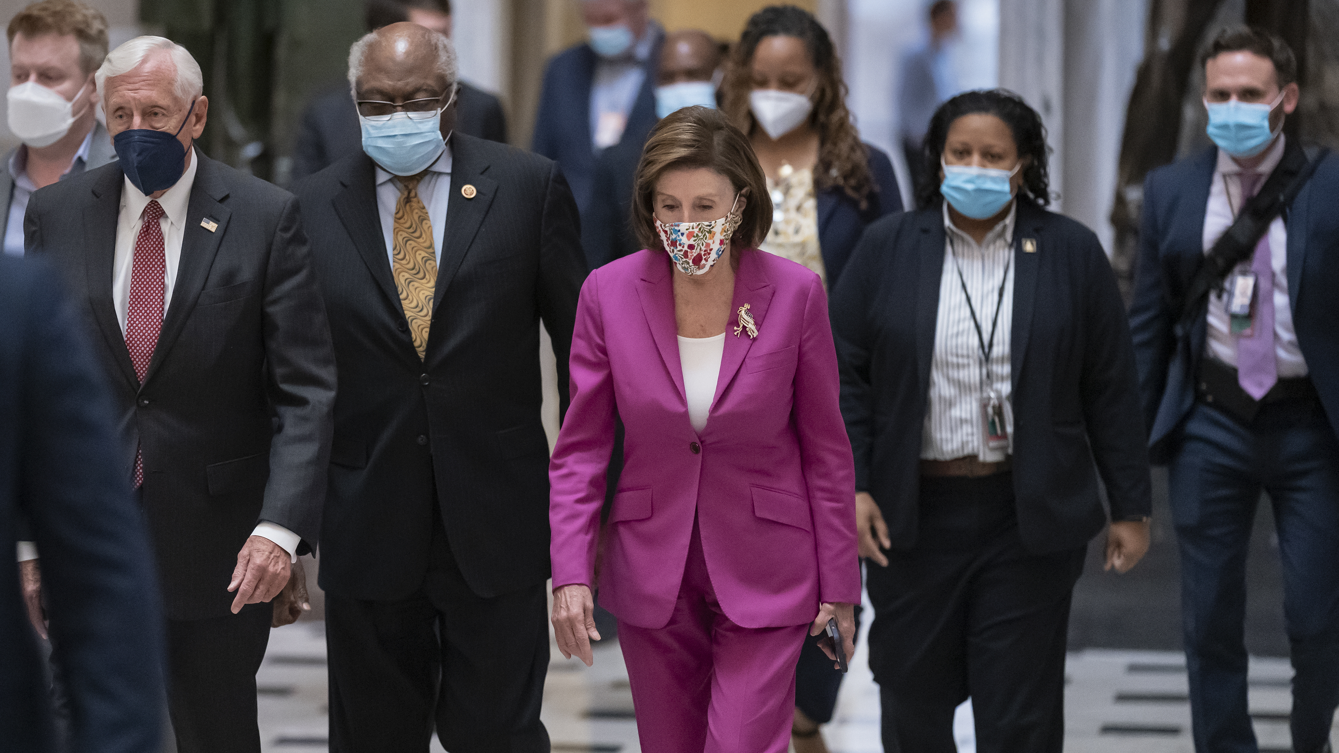 Speaker of the House Nancy Pelosi, D-Calif., (center) joined from left by House Majority Leader Steny Hoyer, D-Md.; and House Majority Whip James Clyburn, D-S.C., walks to update reporters after day of delays in the vote to advance President Joe Biden's domestic policy package at the U.S. Capitol on Friday.
