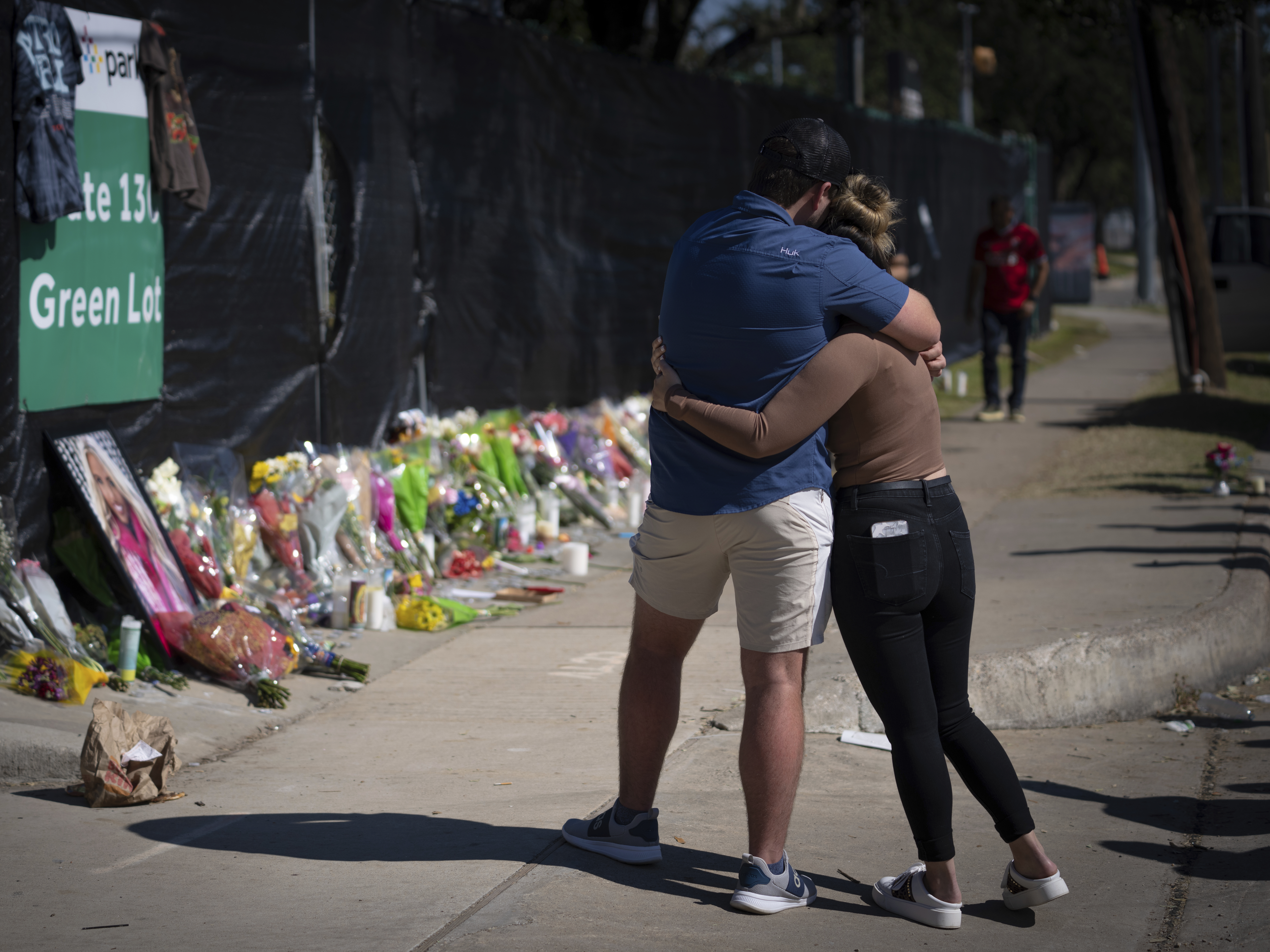 Two people who knew someone killed during the deadly Travis Scott concert at Houston Astroworld embrace at a memorial on Sunday.