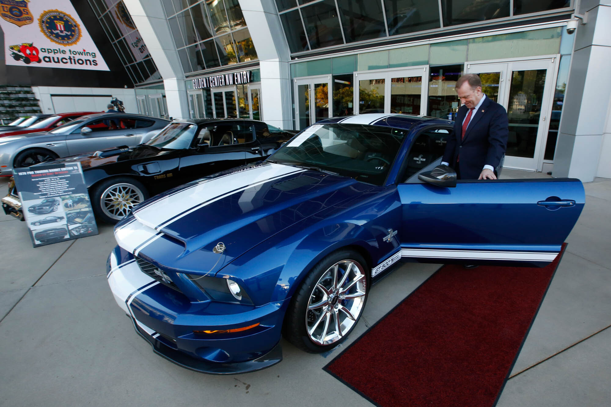 McGregor Scott, who was the the U.S. Attorney for the Eastern District of California in 2019, looks over a cars seized from Jeff and Paulette Carpoff in Sacramento, Calif. The Carpoffs owned a San Francisco Bay Area solar energy company and pleaded guilty for participating in what federal prosecutors called a massive Ponzi scheme that defrauded investors of $1 billion.