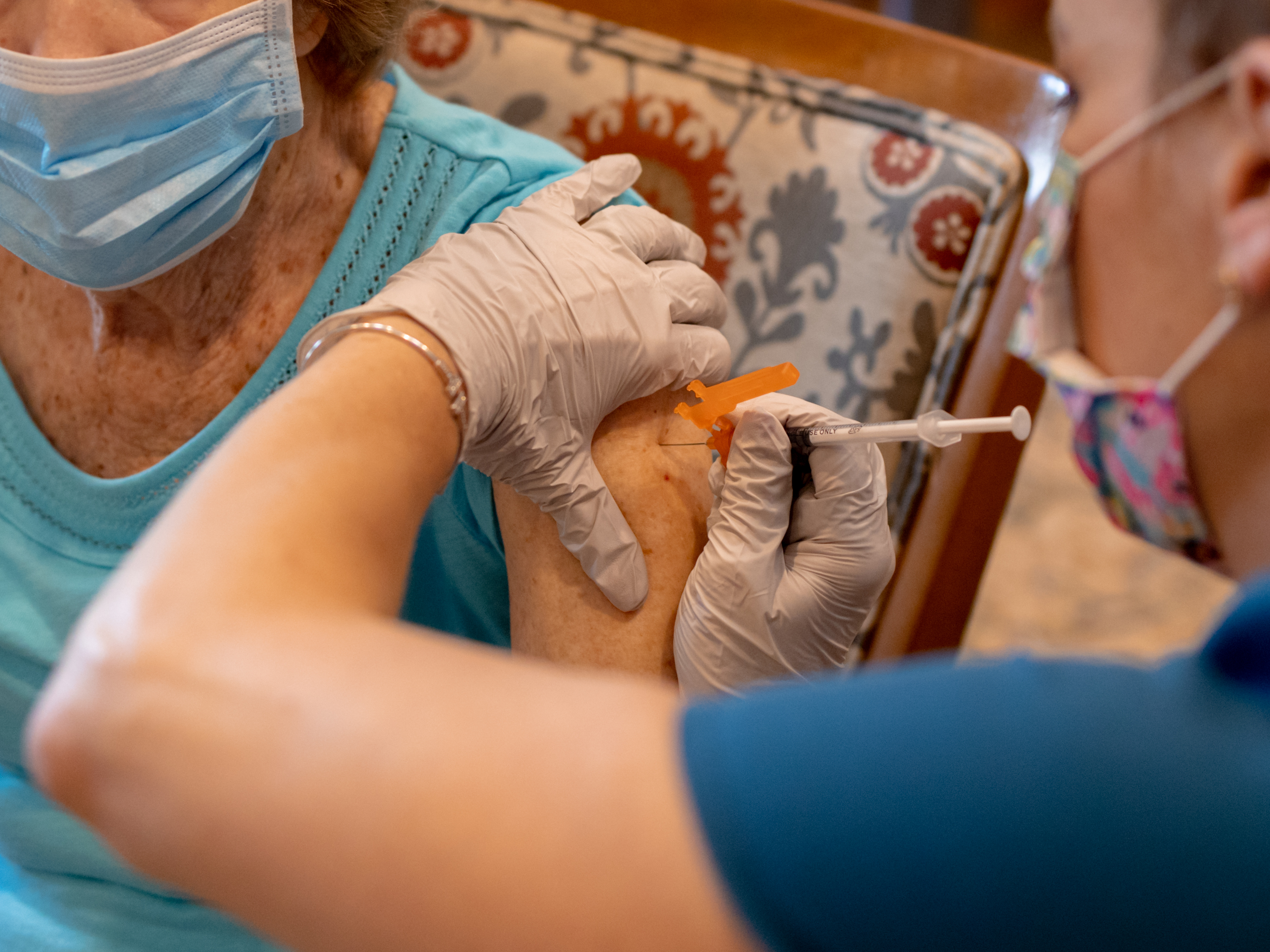 A health care worker administers a third dose of the Pfizer-BioNTech COVID-19 vaccine at a senior living facility in Worcester, Pa., in August. (Bloomberg via Getty Images)
