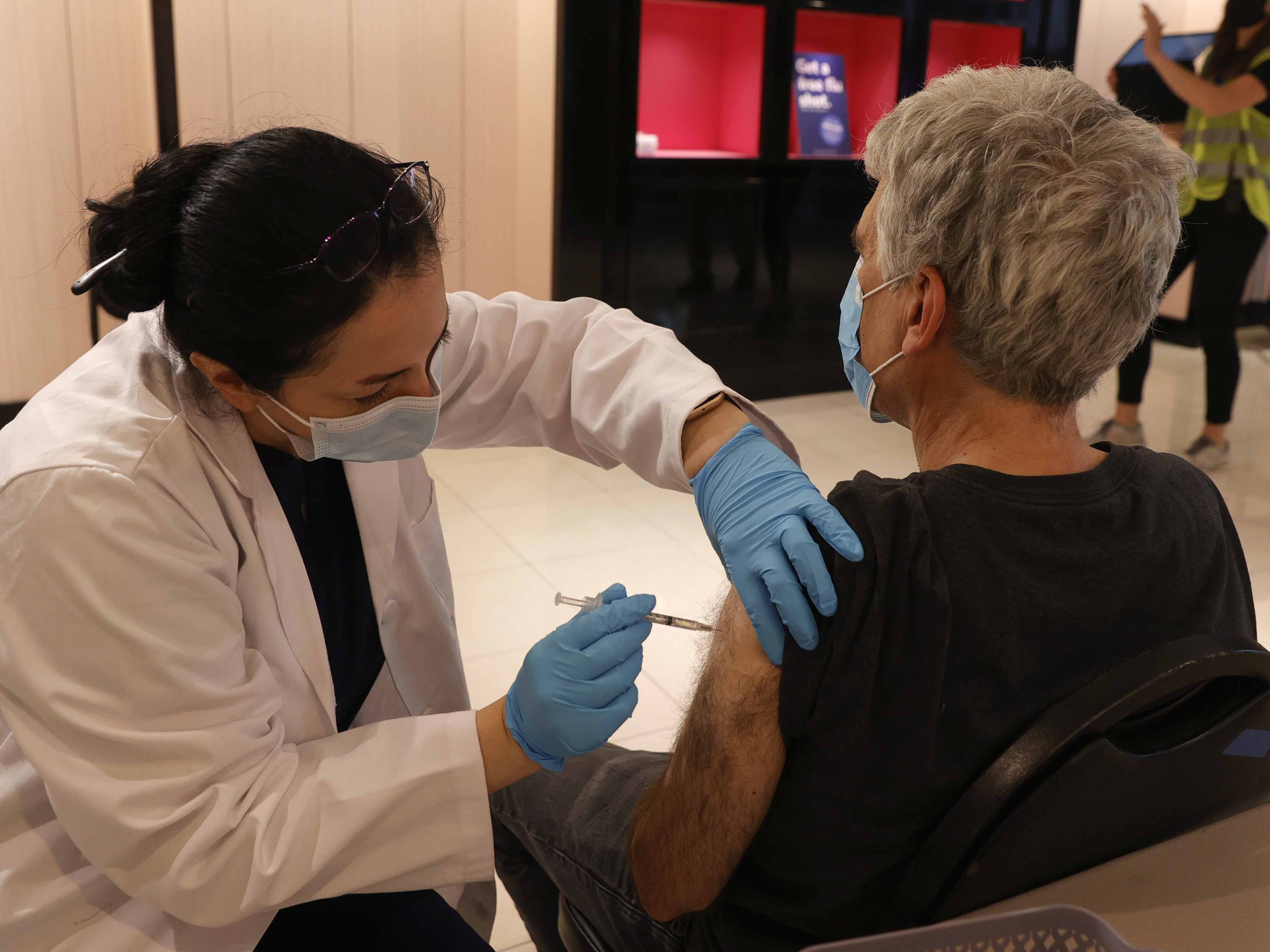 Safeway pharmacist Shahrzad Khoobyari administers a Pfizer-BioNTech COVID-19 booster shot into the arm of Norman Solomon in San Rafael, Calif., in October. (Getty Images)