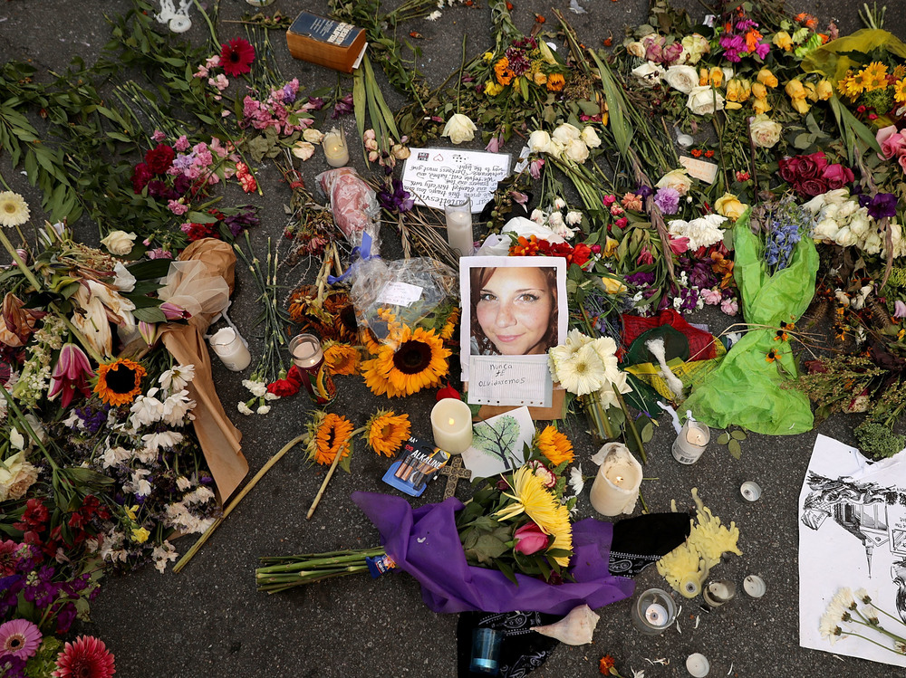 Flowers and candles surround a photograph of Heather Heyer on the spot where she was killed and 19 others injured when a car slammed into a crowd of people protesting against a white supremacist rally in August 2017 in Charlottesville, Virginia. (Getty Images)