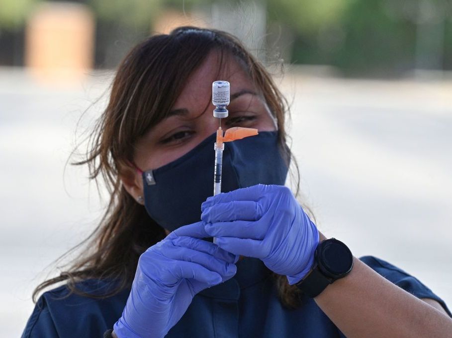 Booster shots are authorized for all U.S. adults, but some are wondering if they need them. A nurse fills a syringe with a Pfizer-BioNTech dose at a pop-up vaccine clinic in the Arleta neighborhood of Los Angeles. (AFP via Getty Images)