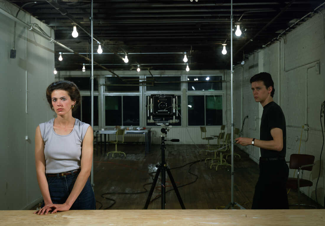 An alternative looking girl standing in a studio wearing a band