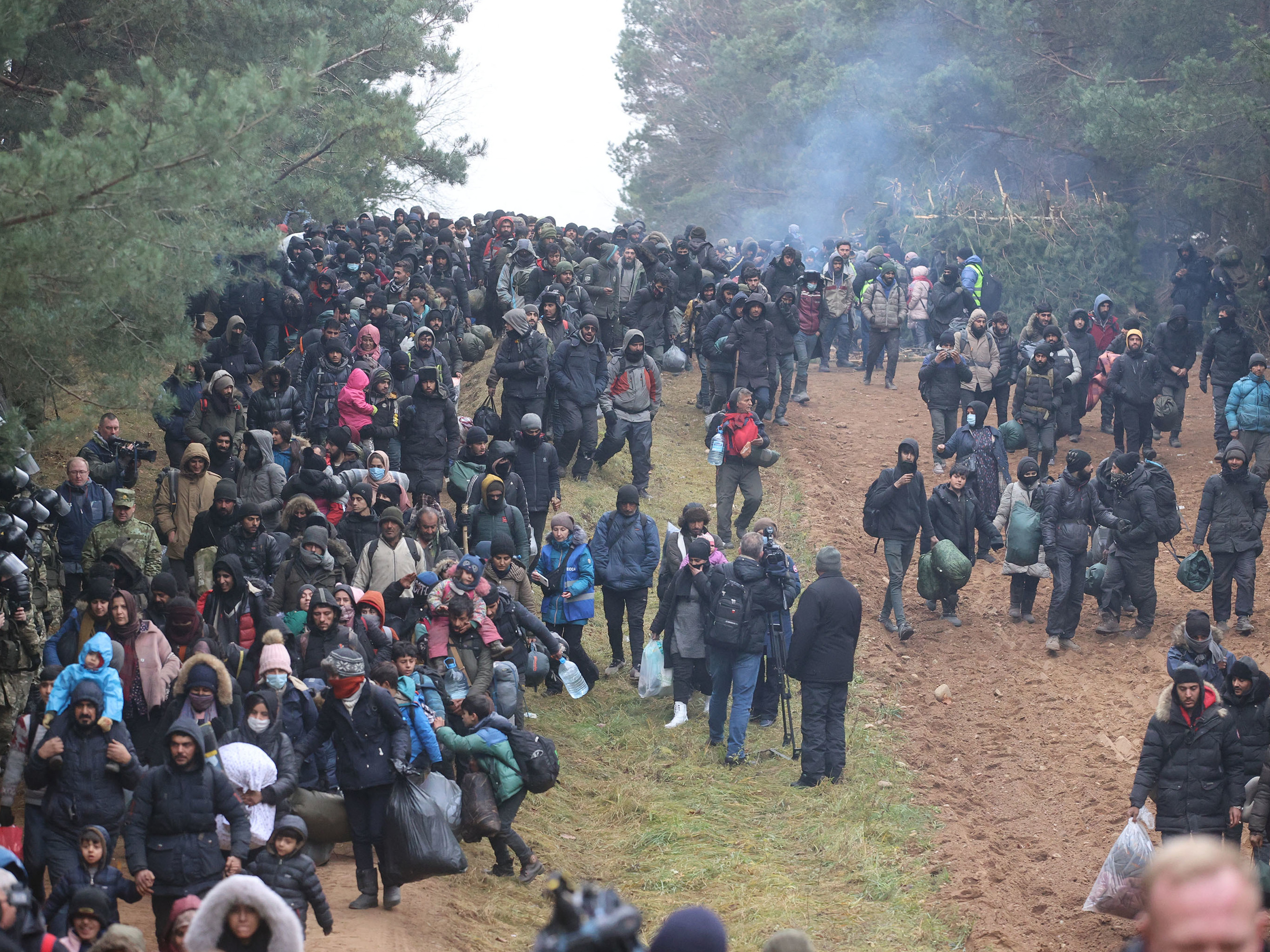 Migrants head toward a border checkpoint on the Belarusian-Polish border on Nov. 15. U.S. officials have accused Belarusian leader Alexander Lukashenko of taking advantage of desperate migrants. (BELTA/AFP via Getty Images)