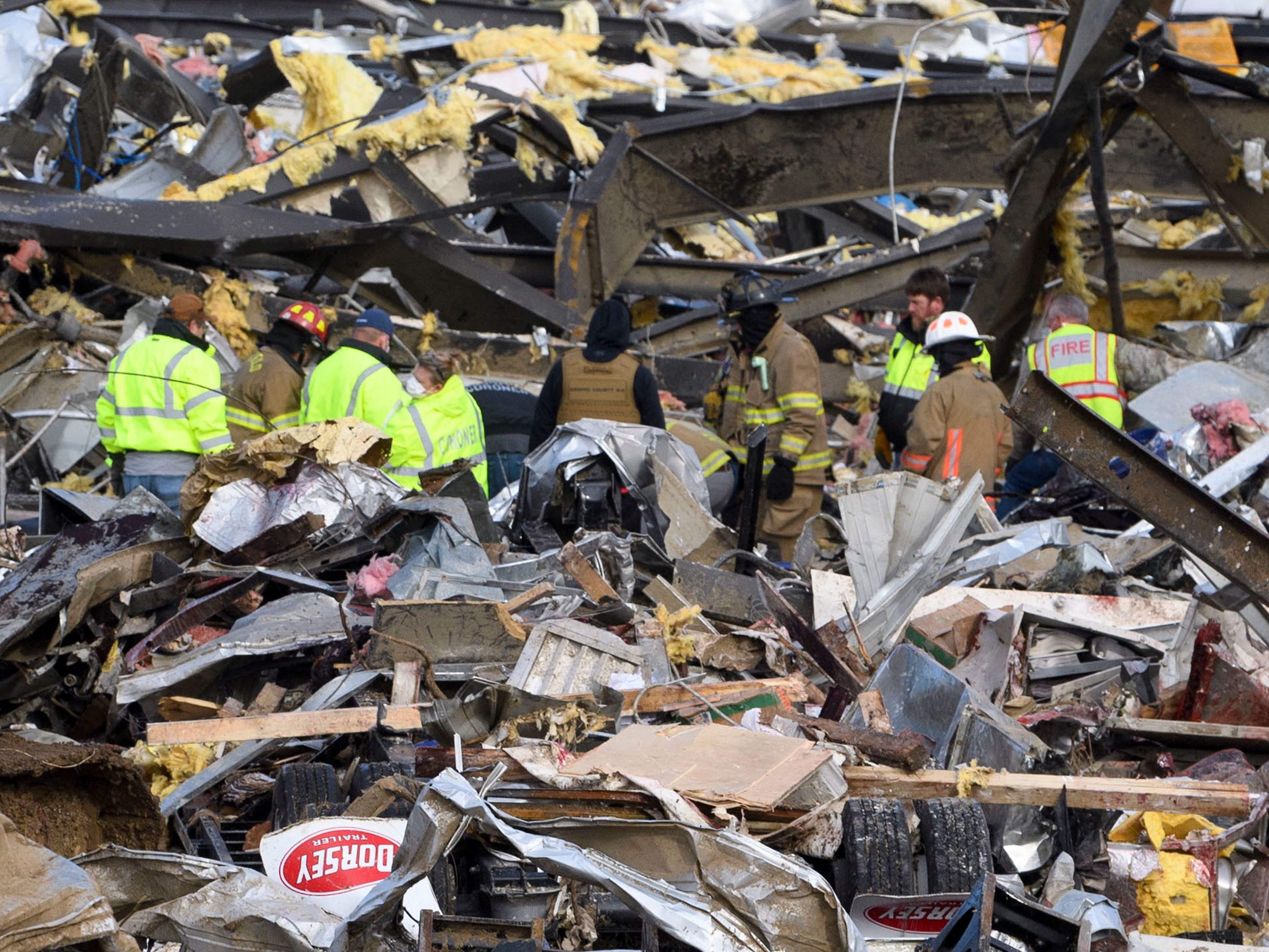 Emergency workers search what is left of the Mayfield Consumer Products Candle Factory on Saturday after it was destroyed in Mayfield, Ky.