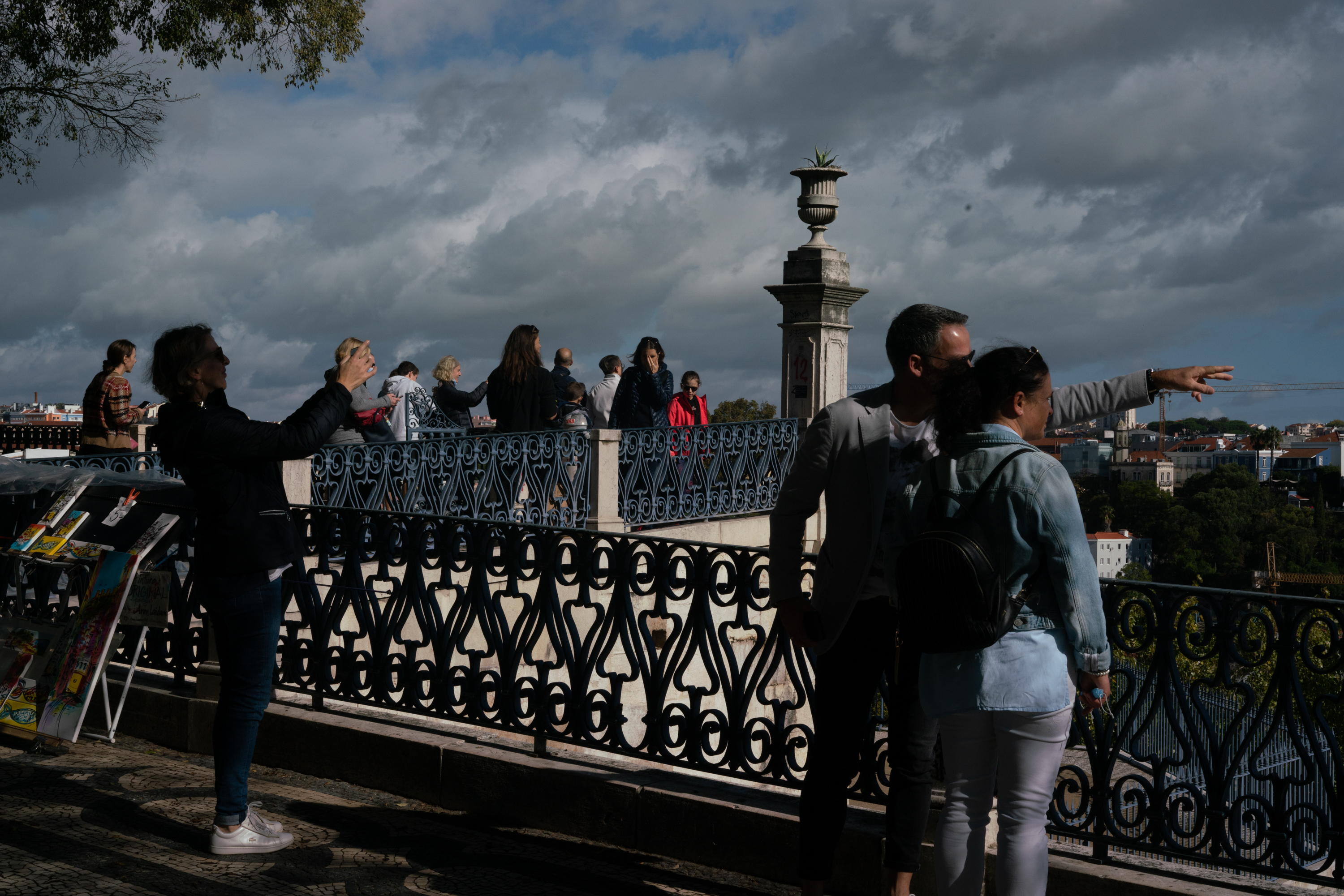 People look at the cityscape at the Miradouro de SÃ£o Pedro de AlcÃ¢ntara in Lisbon, Portugal. (NPR)
