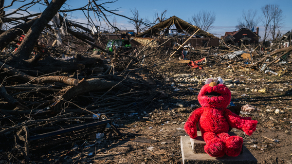 An Elmo doll is seen atop a community memorial in a decimated field on Tuesday in Mayfield, Ky. Images and video showed the town was devastated by tornadoes.