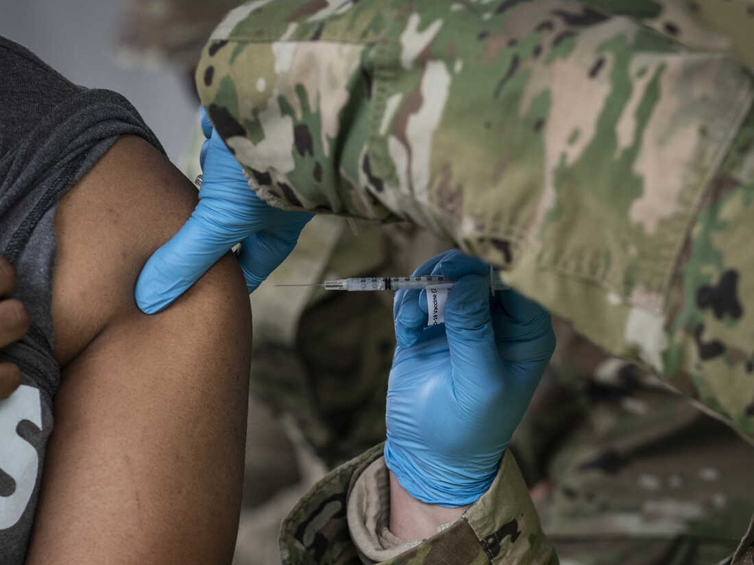 BOWIE, MD - FEBRUARY 06: A man receives a coronavirus vaccine from a member of the National Guard in the parking lot of Six Flags on February 6, 2021 in Bowie, Maryland. Maryland officially entered Phase 1C of COVID-19 vaccine distribution including people over age 65, U.S. Postal Service employees, and workers in manufacturing and agriculture. (Photo by Sarah Silbiger/Getty Images)