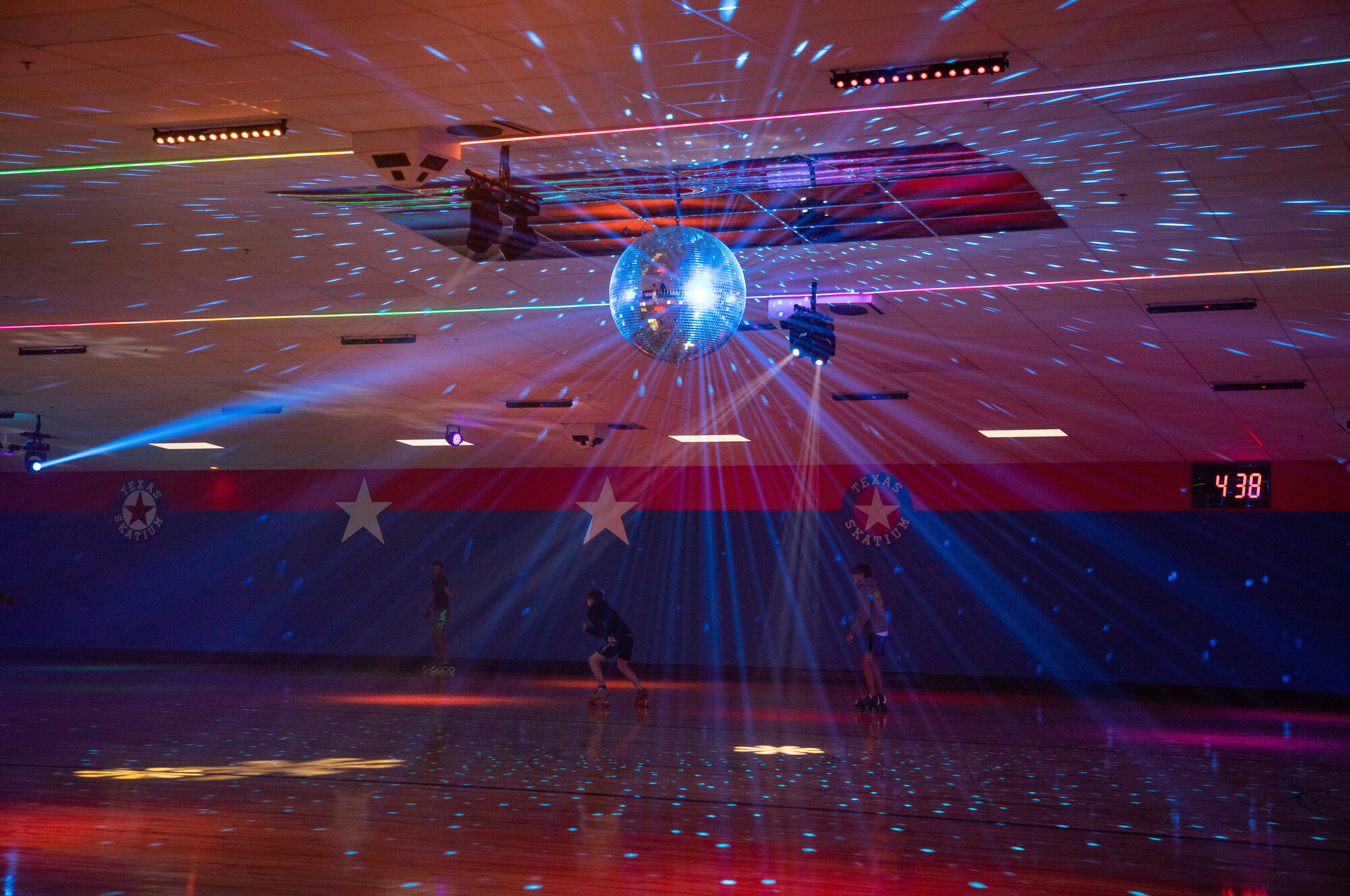 The disco ball shines on rollerbladers on the first evening of the Texas Skatium reopening in Garland, Texas.