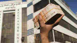 Afghan currency slides and prices surge as already battered economy worsens