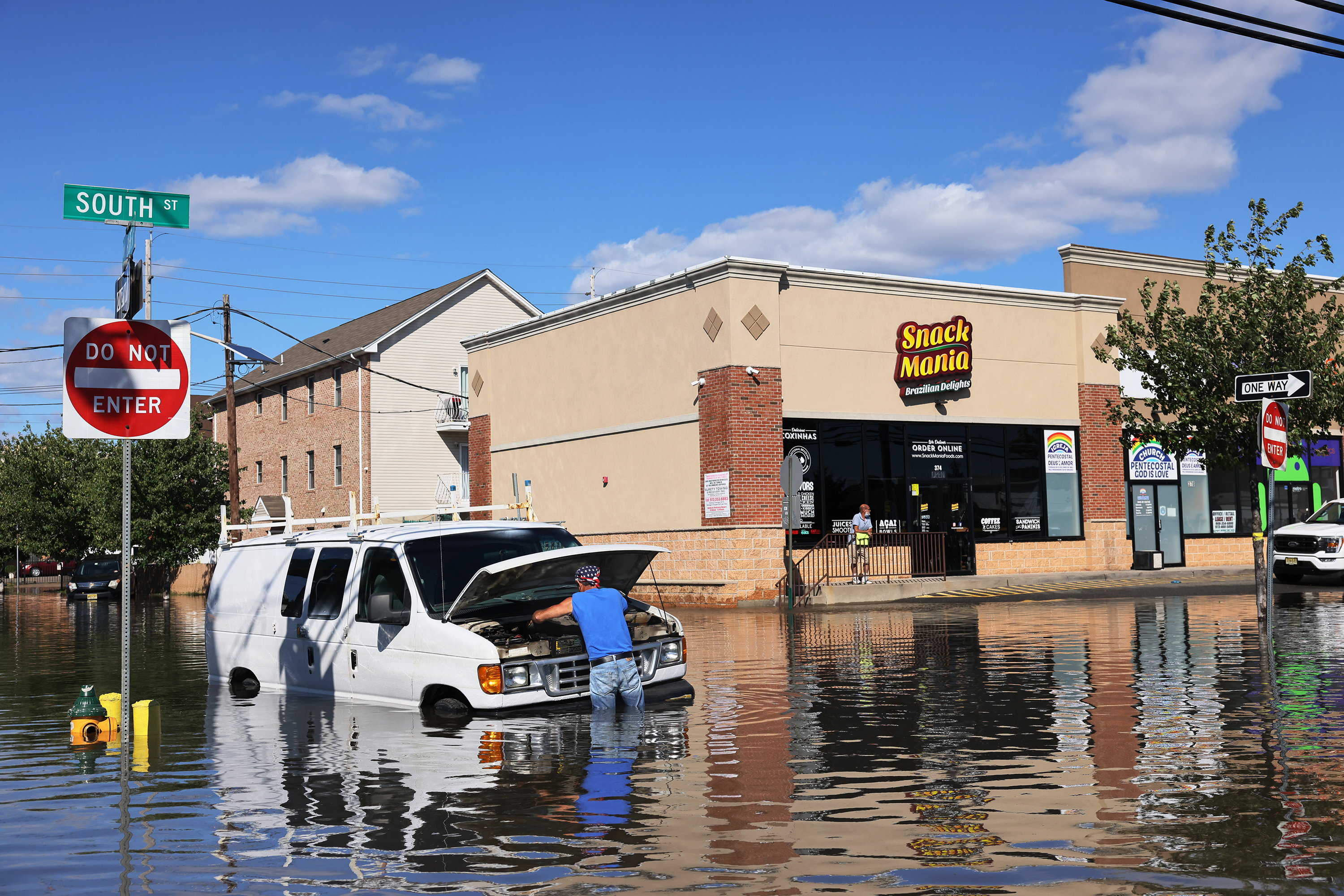 Abilio Viegas attempts to fix his flooded van on South Street in Newark, New Jersey after flooding cause by the remnants of Hurricane Ida. (Getty Images)