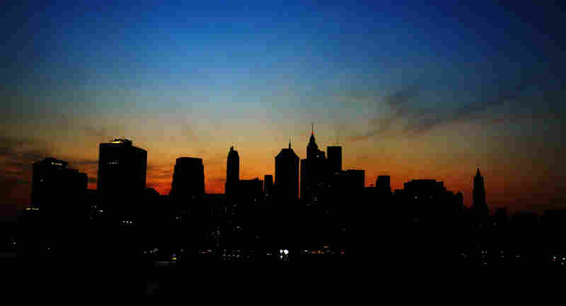 The sun sets over the dark Manhattan skyline on August 14, 2003. A power outage affected large parts of the northeastern United States and Canada.