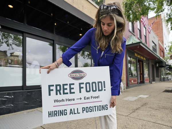 An employee at a restaurant in Chagrin Falls, Ohio, puts up a sign on June 3, 2021, looking for workers with the promise of free food for new hires.