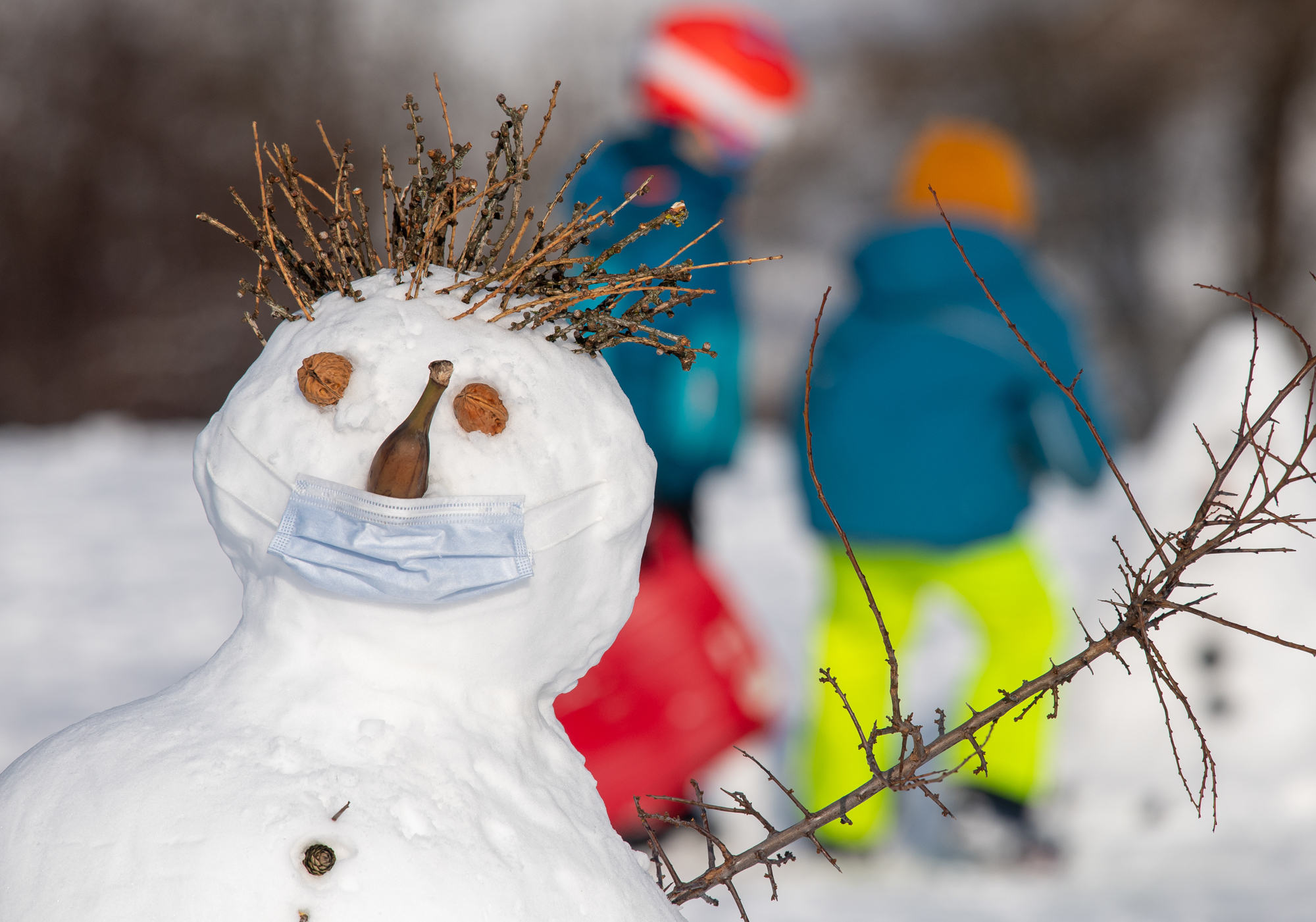 This German snowman wears a protective mask over its banana nose and mouth, but experts say the risk of catching COVID outdoors is slim. (Peter Kneffel)