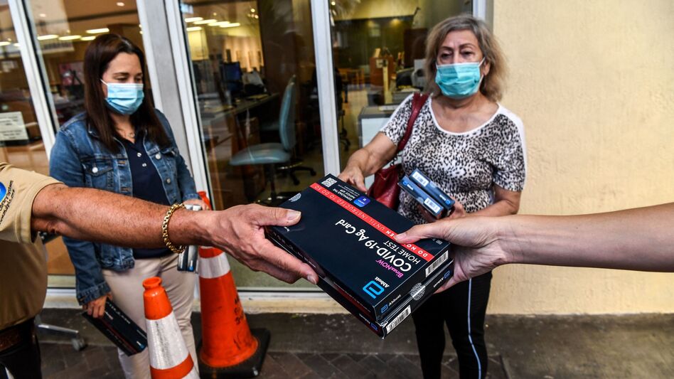 Employees of the Miami-Dade Public Library System distribute Covid-19 home rapid test kits in Miami, Florida, on January 8, 2022. (Chandan Khanna/AFP via Getty Images)