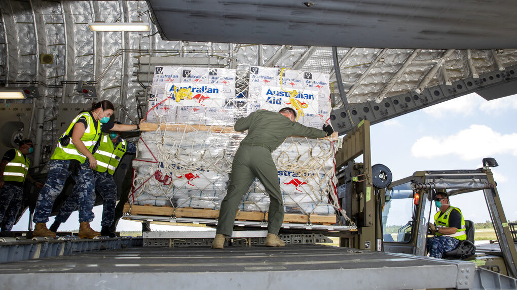 In this photo provided by the Australian Defence Force, personnel unload emergency aid supplies at Tonga