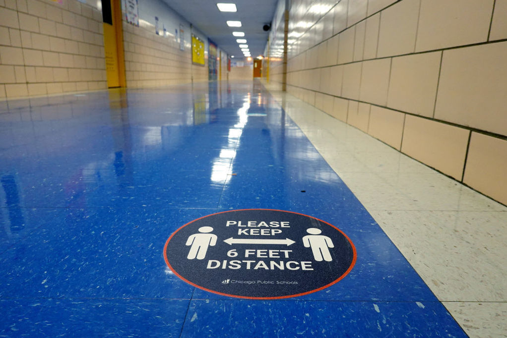 A sign in a hallway at a Chicago elementary school reinforces the mantra of social distancing. (Getty Images)