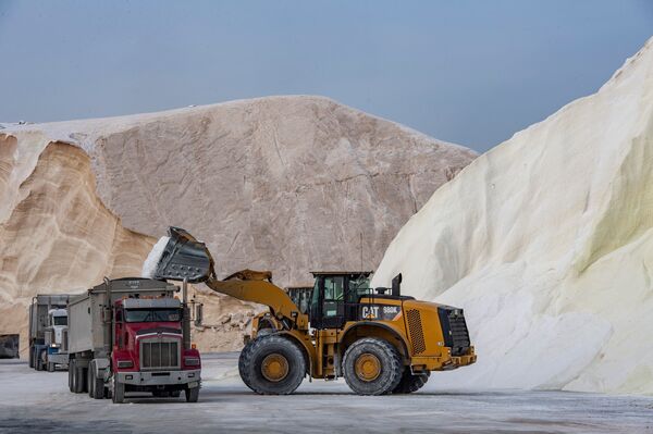 A bulldozer loads trucks with salt at Eastern Salt in Chelsea, Mass., on Friday. The salt company serves dozens of towns and cities in Massachusetts and the salt will be used to treat roads and highways as the winter storm approaches.