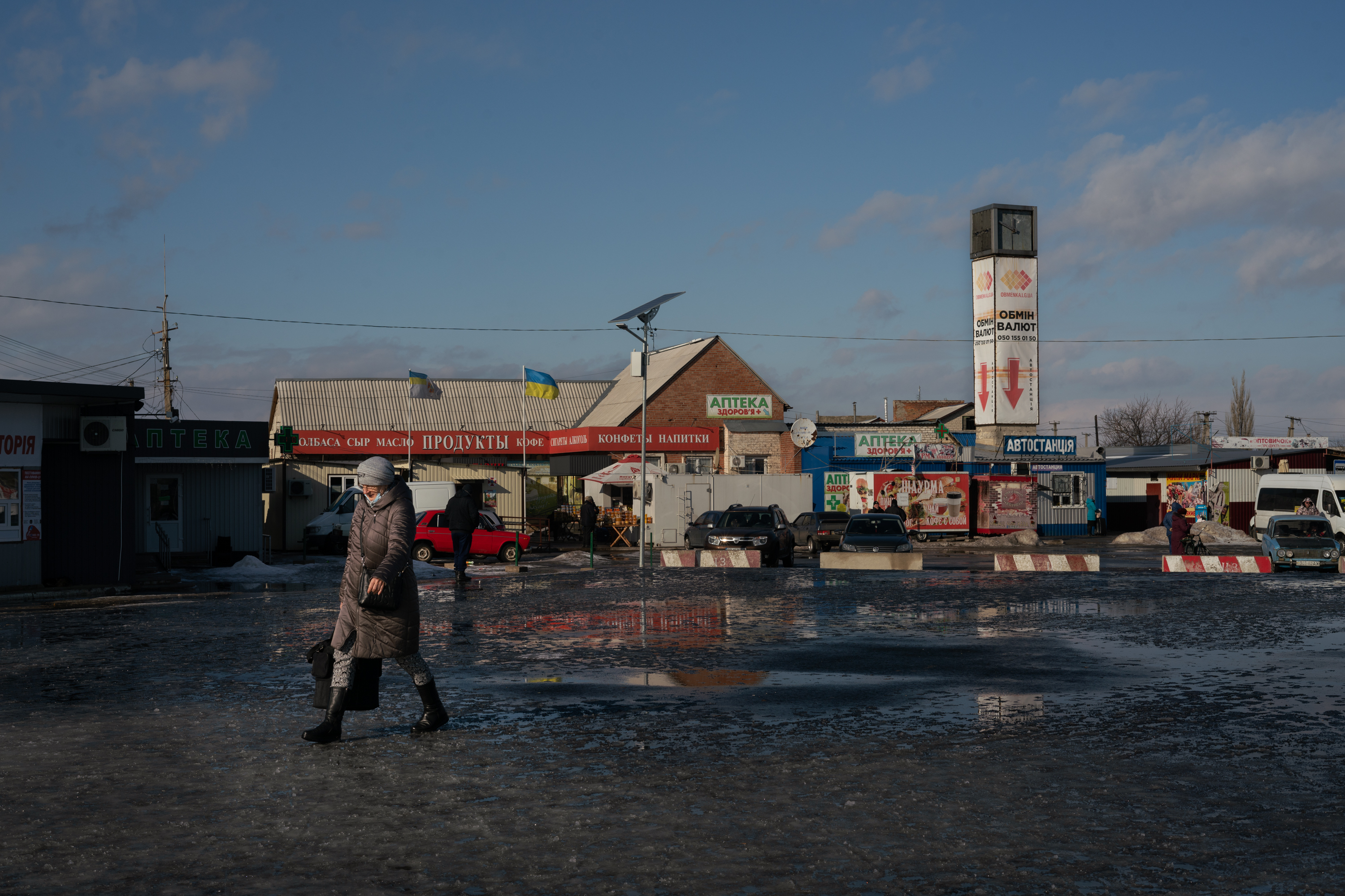 A woman walks towards the only crossing right now between the rest of Ukraine and the northernmost occupied territory, manned by guards on both sides who check documents in Stanytsia Luhanska. (NPR)
