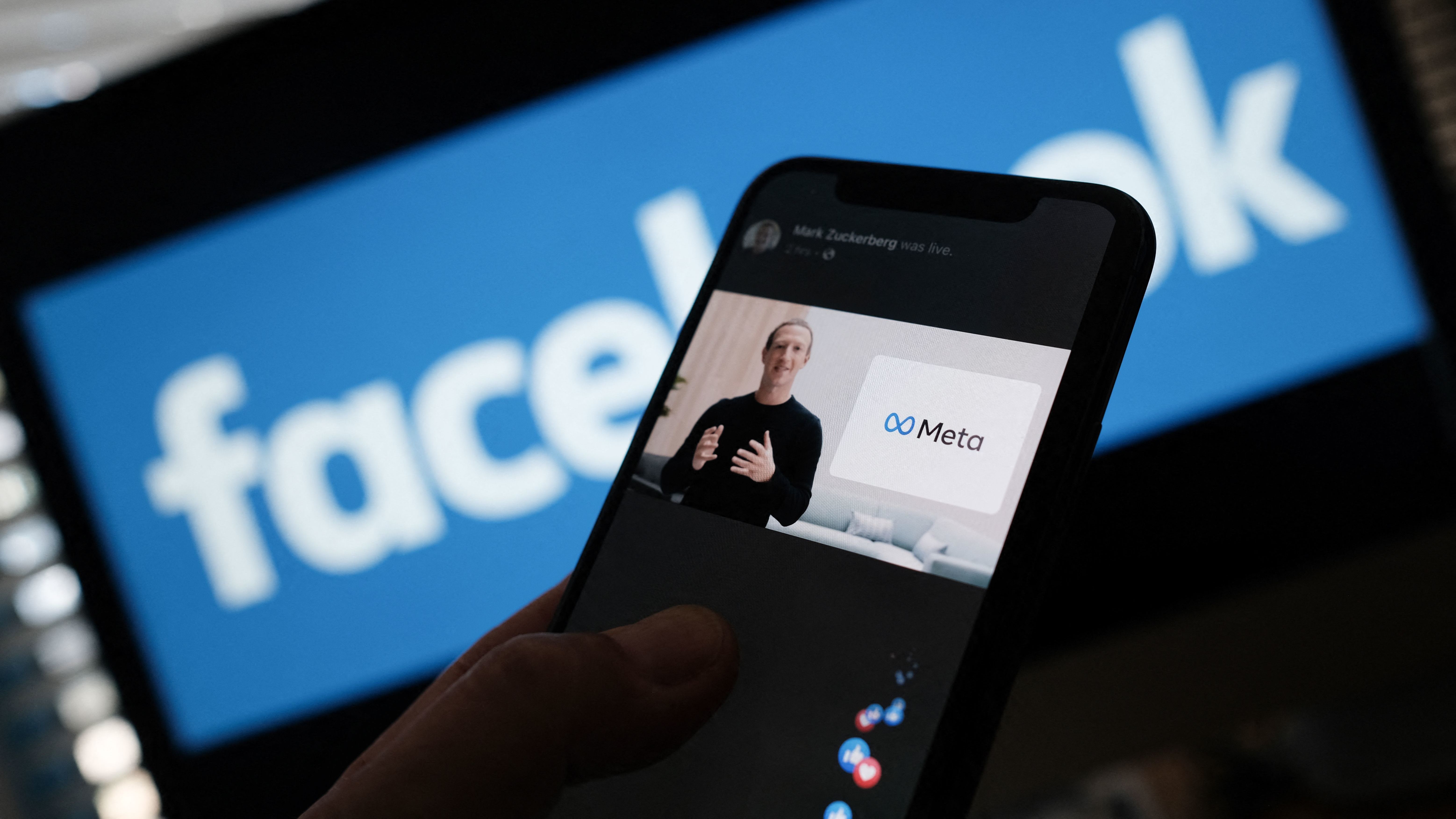 In this illustration photo taken in Los Angeles on Oct. 28, 2021, a person watches on a smartphone as Facebook CEO Mark Zuckerberg unveils the META logo. The name of Facebook's parent company was changed to Meta to represent a future beyond just its troubled social network. (AFP via Getty Images)