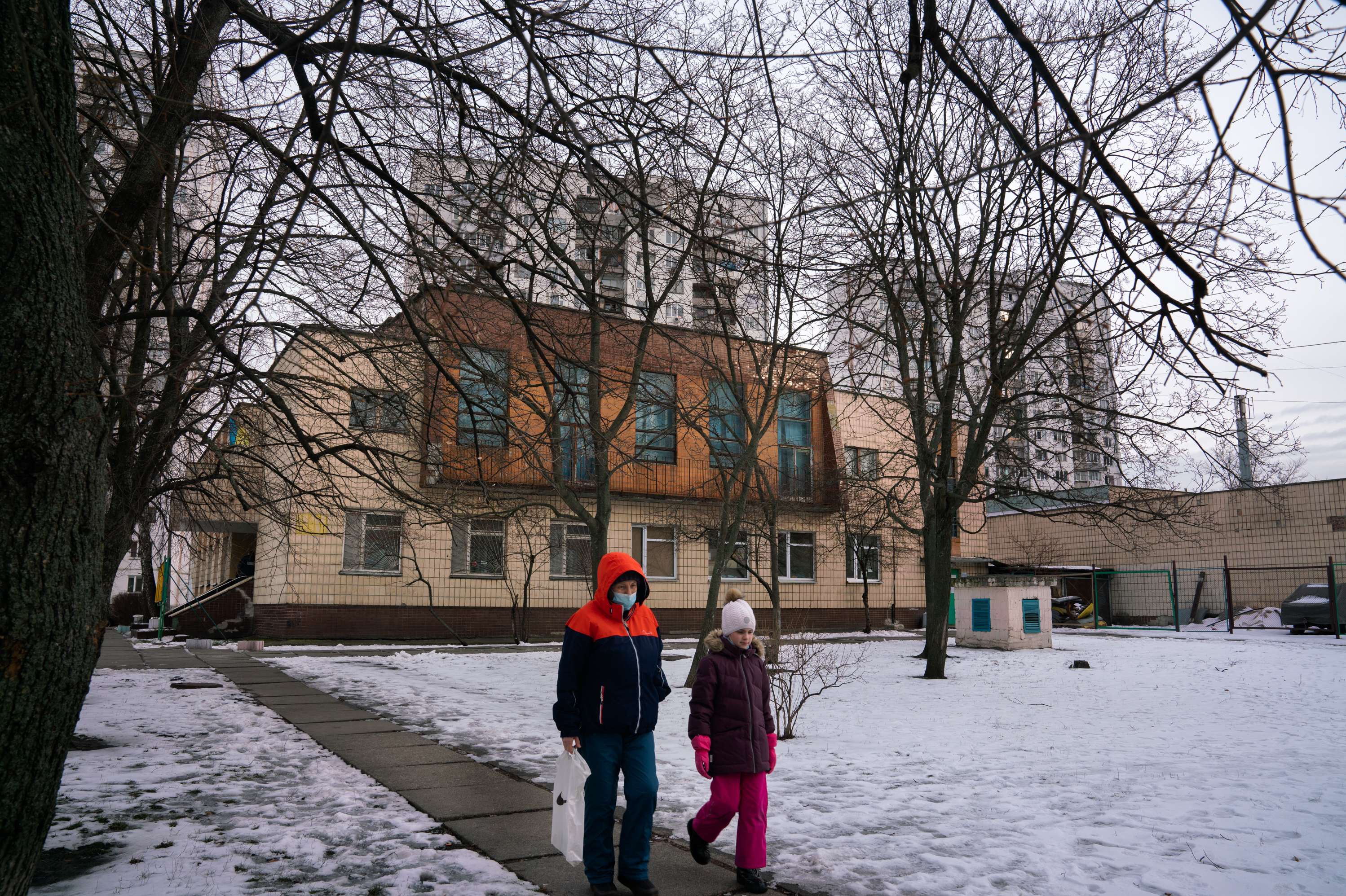 People walk past an administrative building, in the Dniprovskyi residential district of Kyiv, underneath which is a bunker from the 1980s. (NPR)