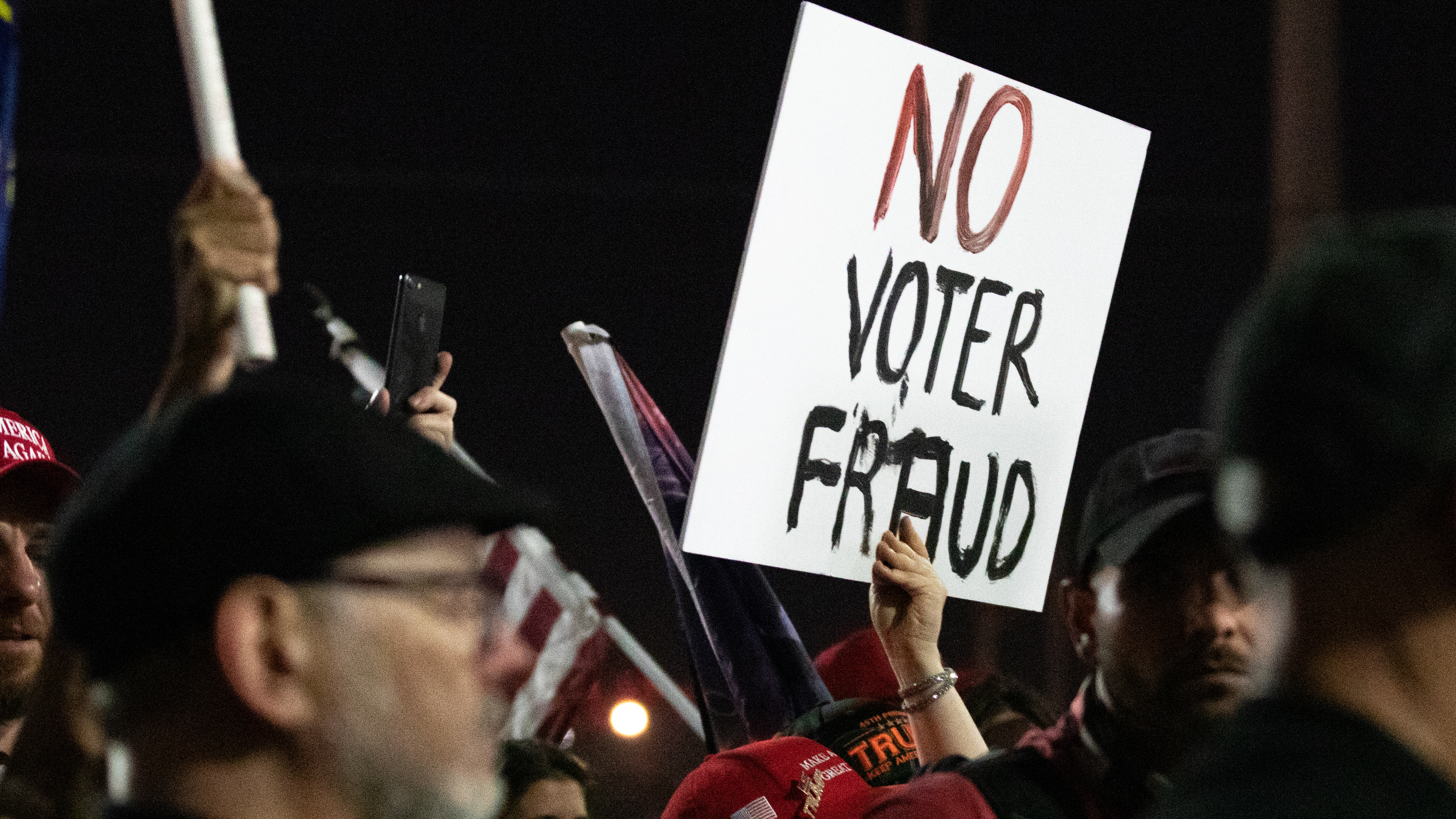 A Trump supporter holds up a &quot;no voter fraud&quot; sign in Arizona in 2020. The accelerating far-right disinformation campaign about a national voter-verification system is taking its toll. (Getty Images)