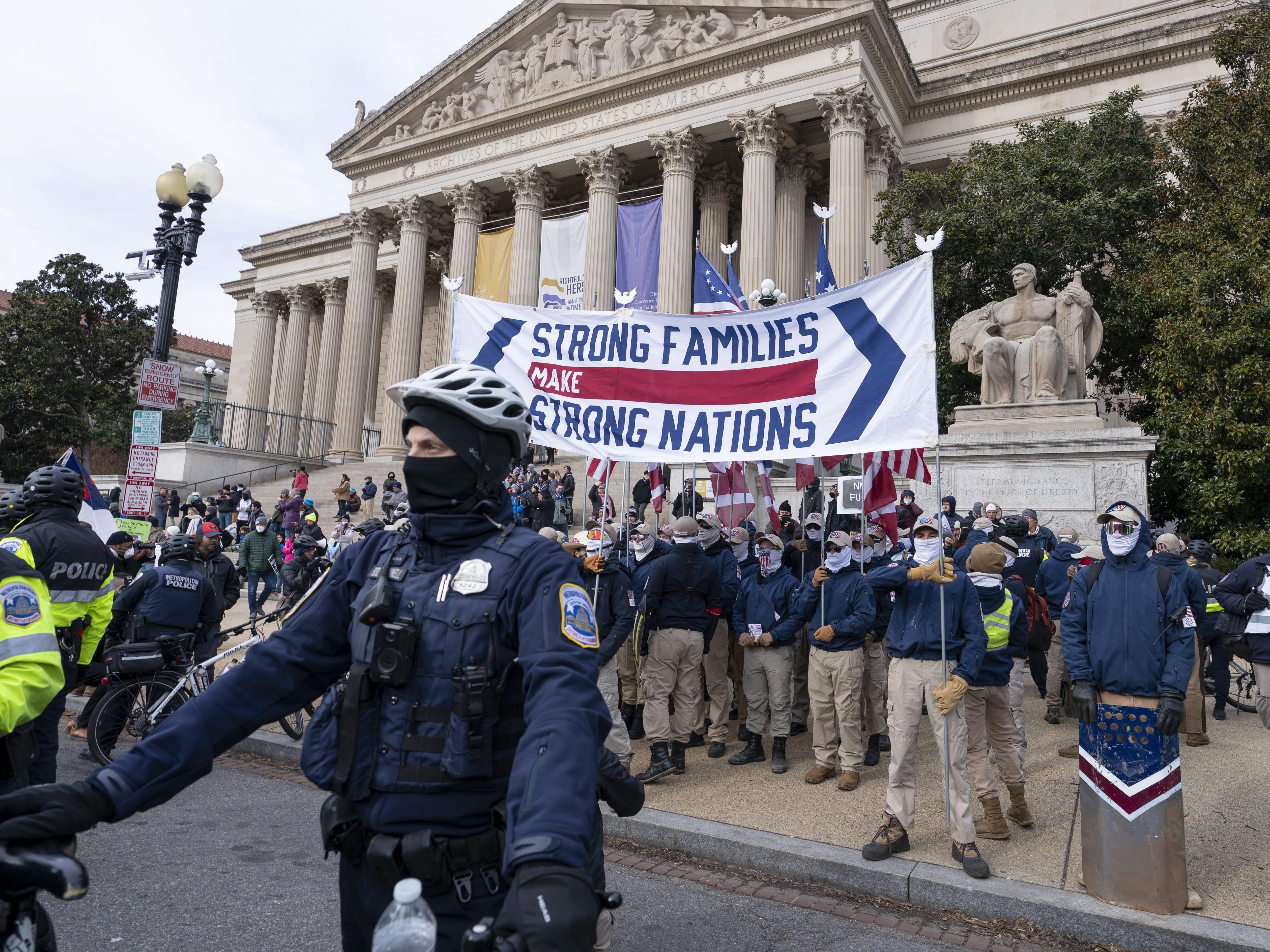 Members of the white supremacist group Patriot Front march on Constitution Avenue near the National Archives in Washington, Friday, Jan. 21, 2022. 1 in 5 Patriot Front applicants say they have ties to the military