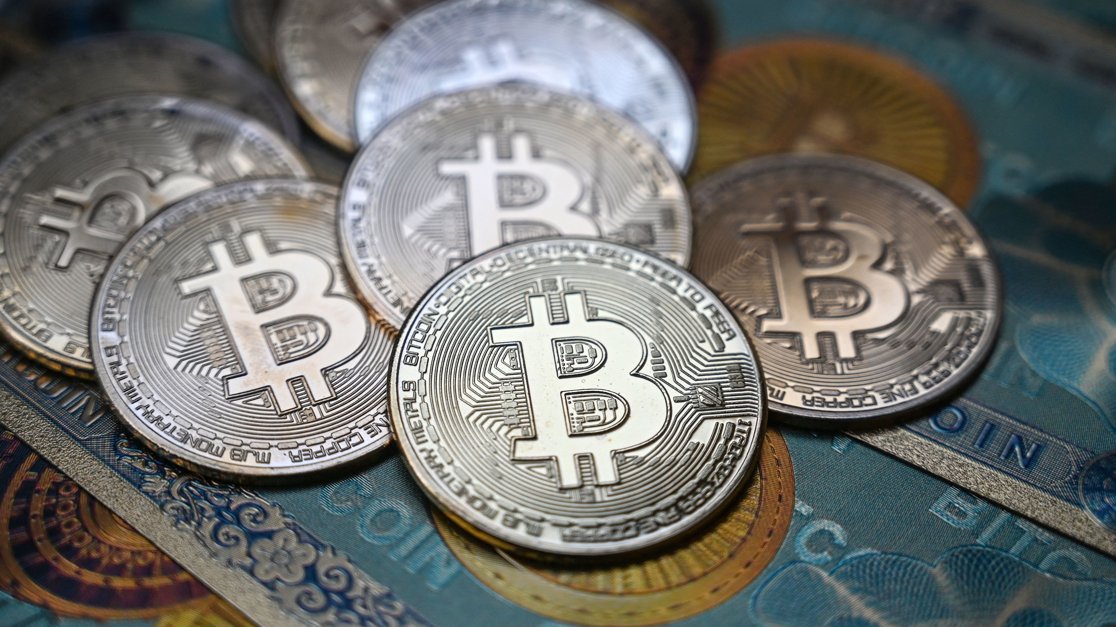 This illustration photograph taken on July 19, 2021 in Istanbul shows a physical banknote and coin imitations of the Bitcoin crypto currency. (Photo by Ozan KOSE / AFP) (Photo by OZAN KOSE/AFP via Getty Images)