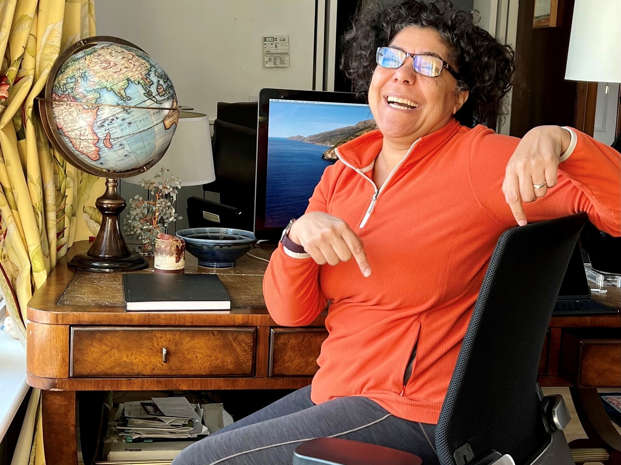 Heidi Brooks, senior lecturer in organizational behavior at the Yale School of Management, points to the chair she discovered was missing from her office on campus. Then she remembered it's been in her home office since she brought it home at the start of the pandemic. (Valerie Small)