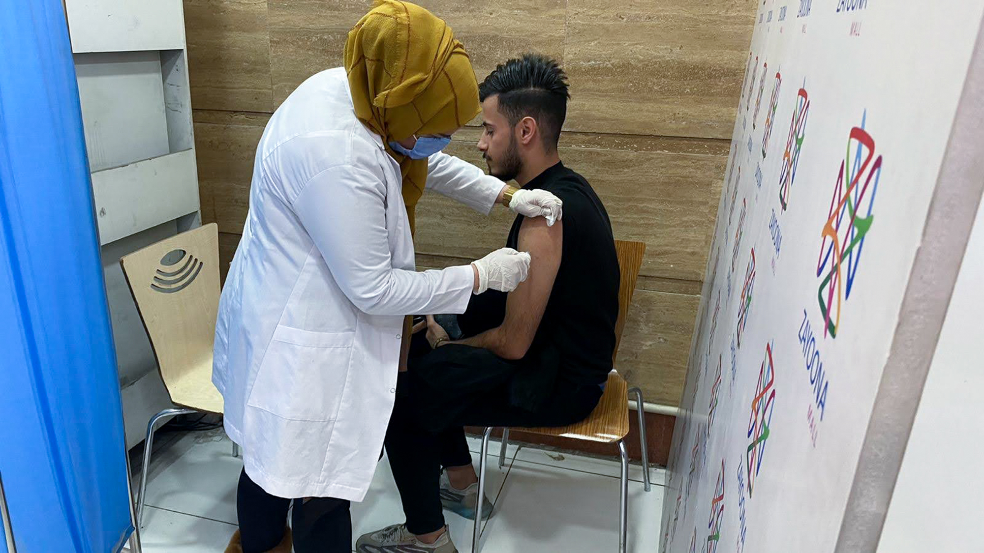 Hussein Raad, a 22-year-old college student, gets his second dose of the Pfizer vaccine at Zayoona Mall in Baghdad.