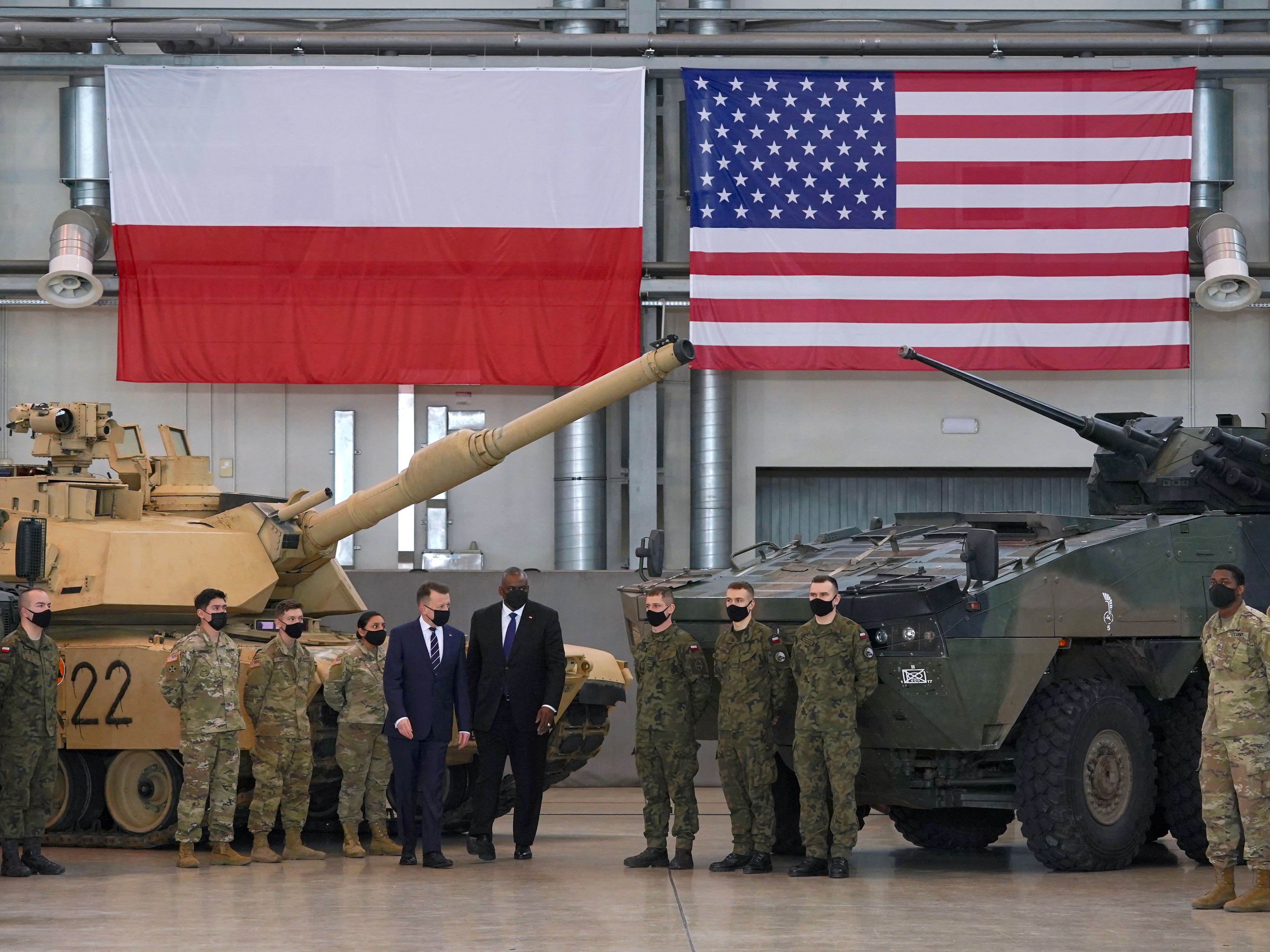 Secretary of Defense Lloyd Austin and Polish Defense Minister Mariusz Blaszczak stand with Polish and U.S. soldiers at the 33rd Air Base of the Polish Air Force near Powidz during a visit last week. (AFP via Getty Images)