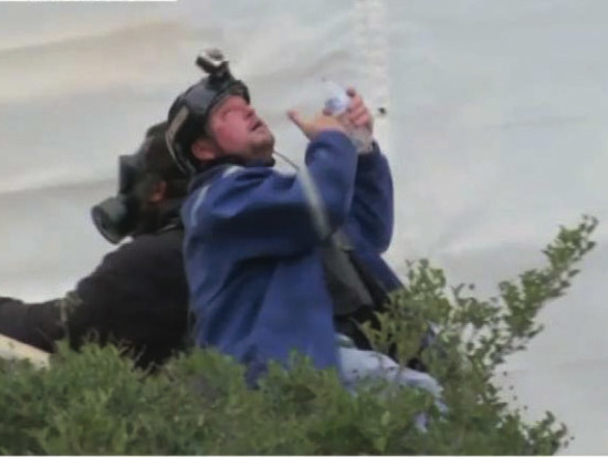 The U.S. government says in its affidavit that this photo shows Guy Reffitt rinsing his eyes outside the Capitol on Jan. 6, 2021, wearing a blue jacket over a tactical vest and a helmet with a camera.