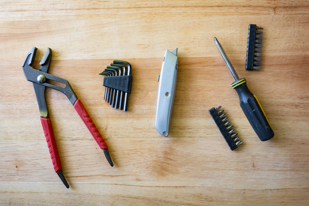 Image of four tools that Mercury Stardust, maintenance technician and TikTok creator, says you should have in your toolbox: Adjustable pliers, multi-screwdriver, an allen key, and a utility knife.